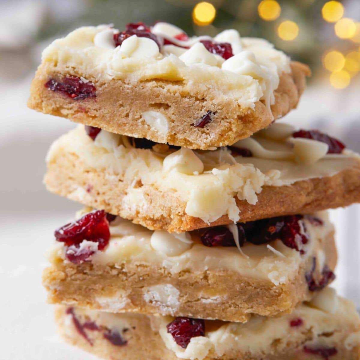 four cranberry bliss bars stacked on top of each other.