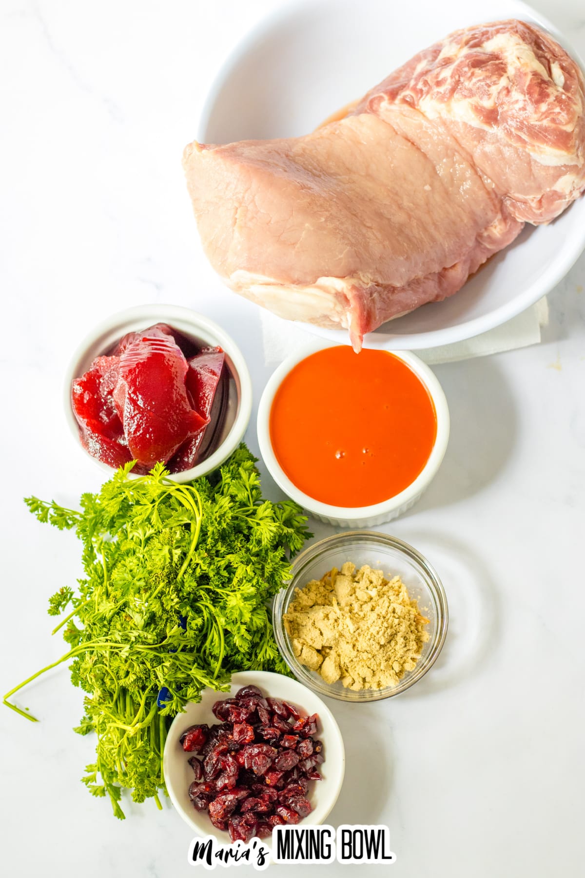 bowls of pork loin, cranberry sauce, onion soup mix, dried cranberrries, fresh parsley, and french dressing.