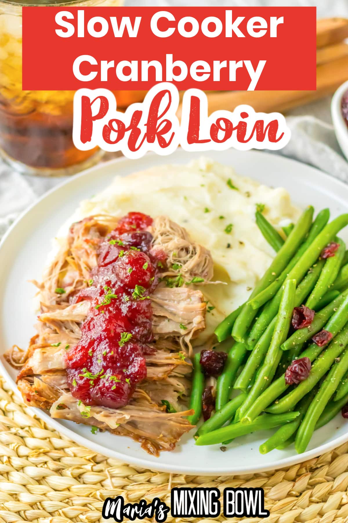 cranberry roast pork loin on a plate with mashed potatoes and green beans.