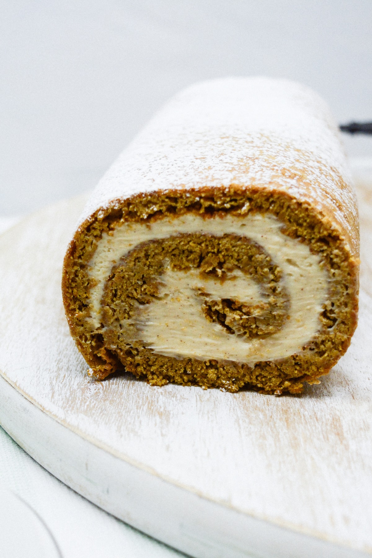 whole gingerbread cake roll with one slice cut off.