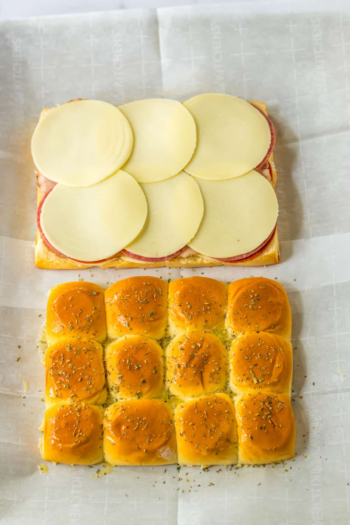 seasoned butter being brushed on top of sub rolls