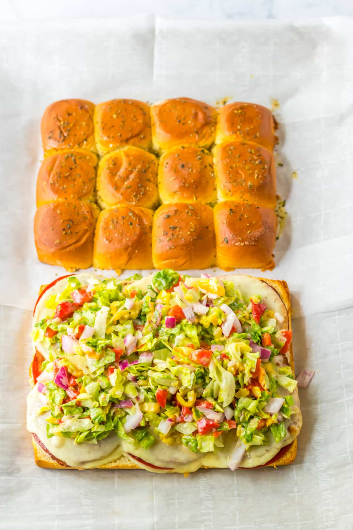 vegetable toppings being added to italian sub sliders