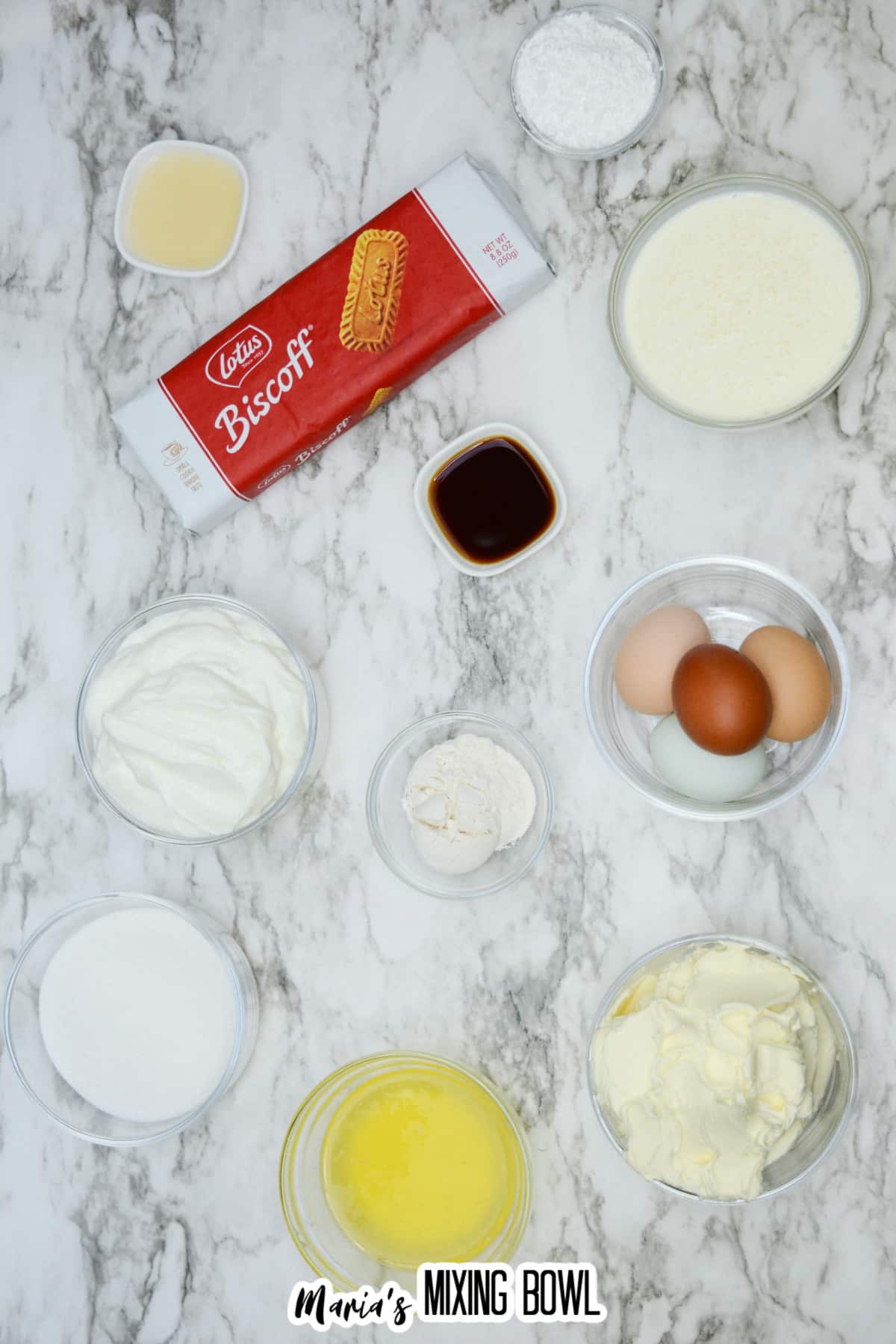 bowls of cream cheese, melted butter, sour cream, sugar, powdered sugar, heavy cream, eggs, flour, and biscoff cookies.