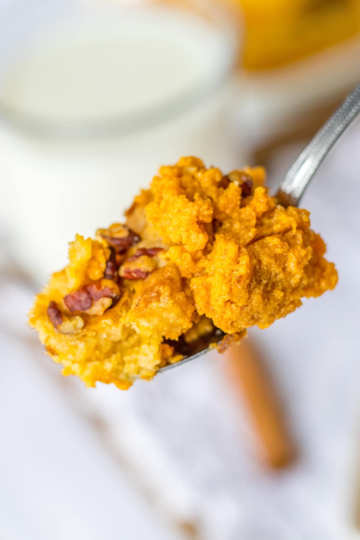 bite of pumpkin crunch dump cake on a fork held in the air.