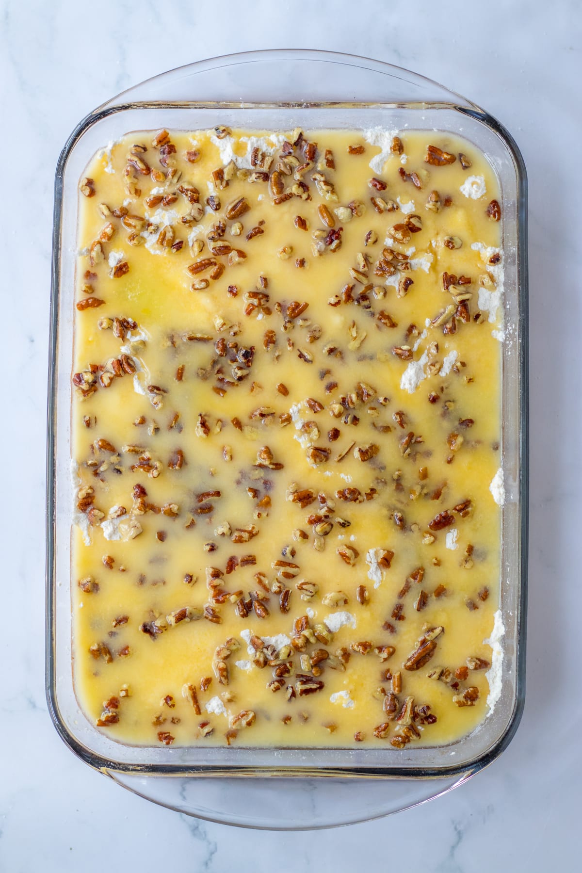 unbaked pumpkin crunch cake in a glass baking dish.
