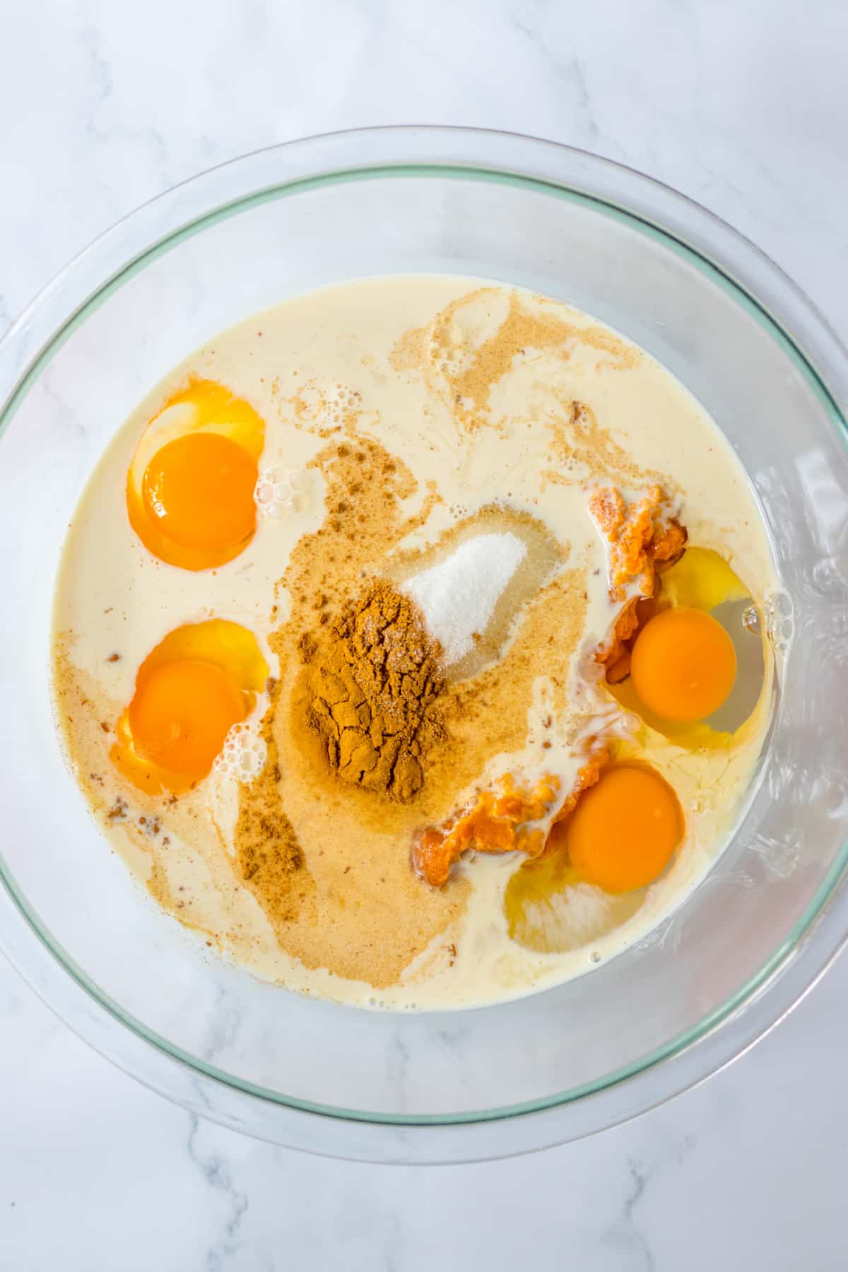 eggs, pumpkin puree, salt and pumpkin pie spice in a glass mixing bowl.