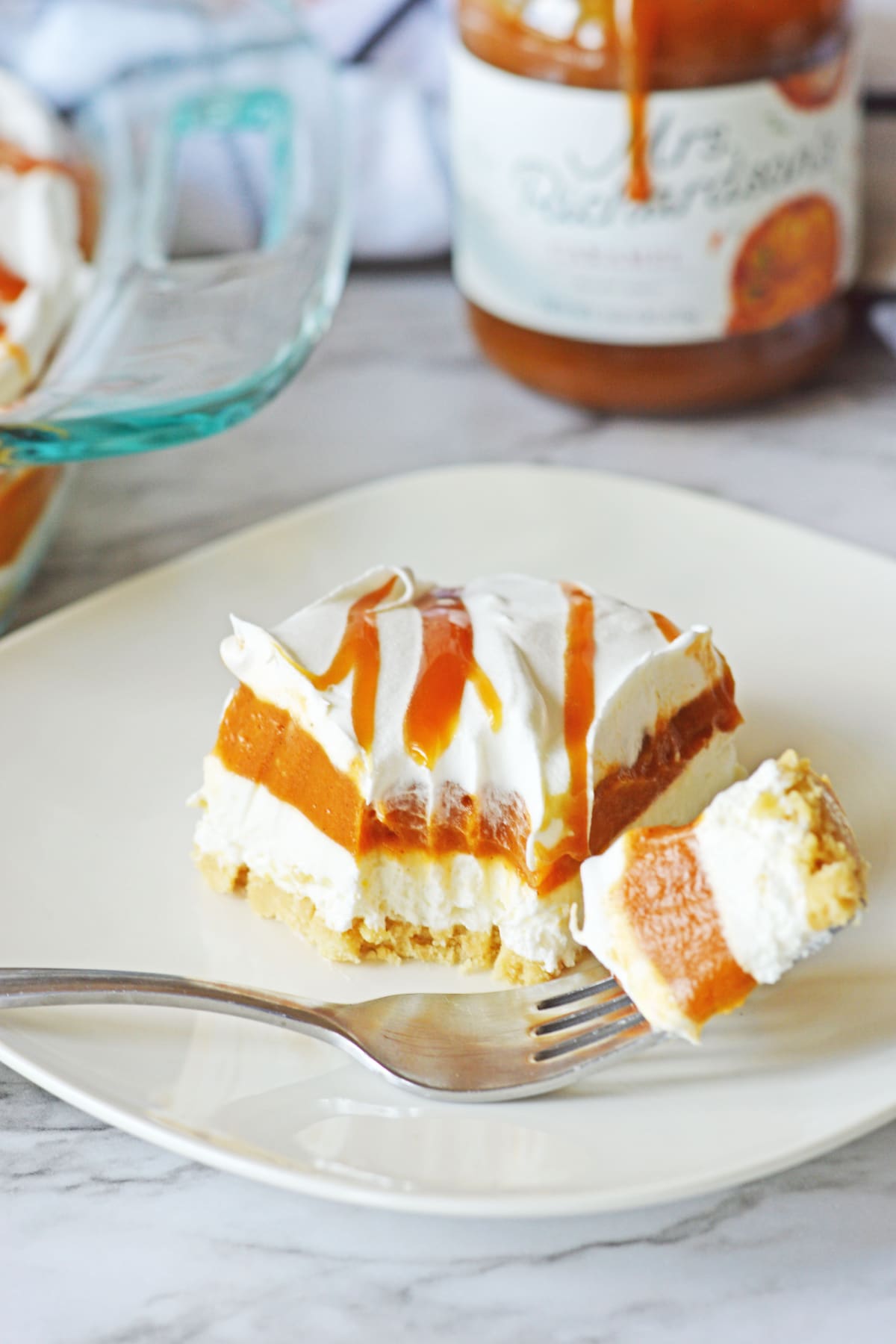 slice of pumpkin lasagna on a plate with a bite on a fork.