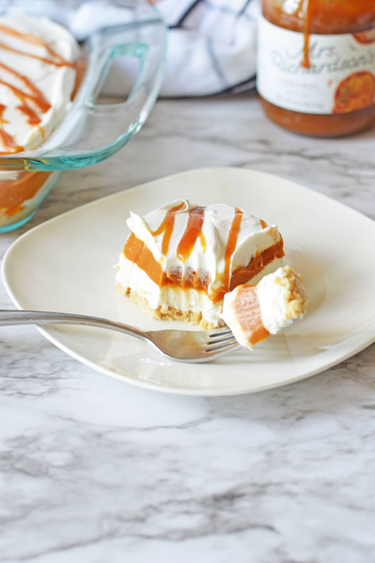 slice of pumpkin lasagna on a plate with a bite on a fork.