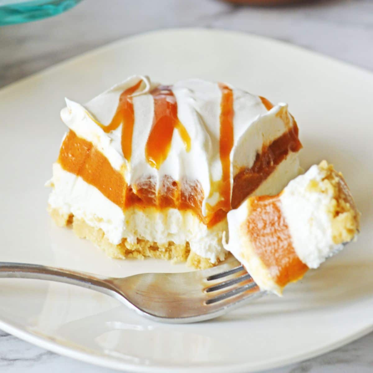 slice of pumpkin lasagna on a plate with a bite on a fork.