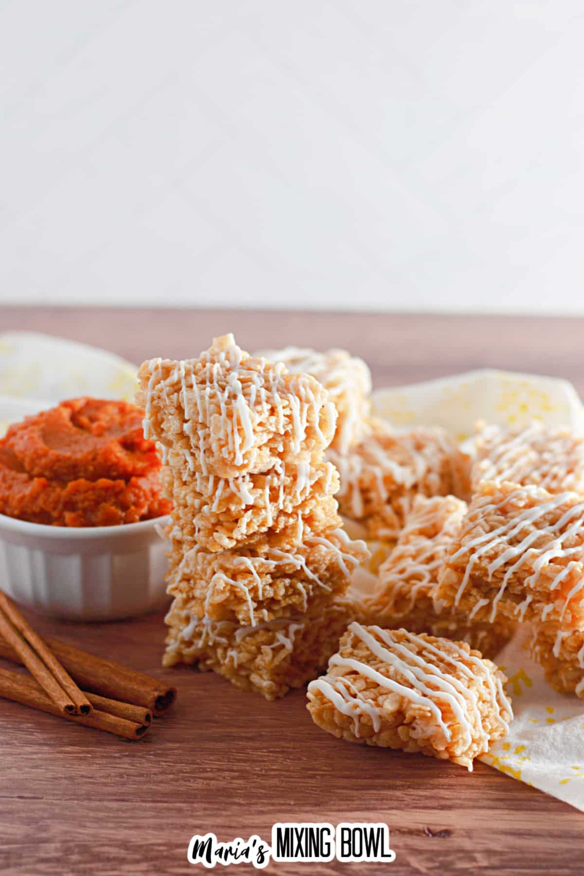 stack of pumpkin spice rice krispies treats on a wooden cutting board.