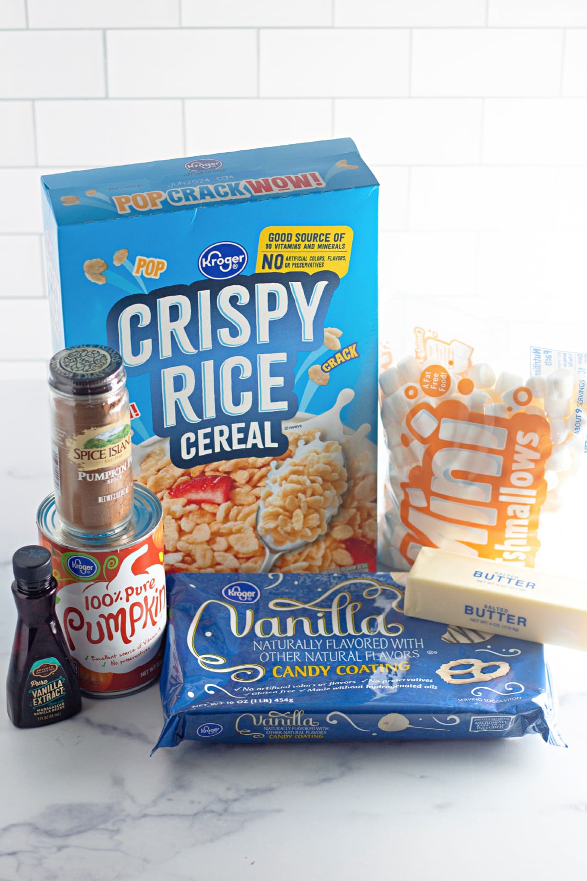 packages of crispy rice cereal, pumpkin spice, pumpkin puree, vanilla extract, vanilla candy coating, mini marshmallows, and a stick of butter.