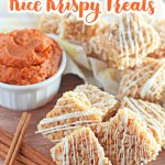stack of pumpkin spice rice krispies treats on a wooden cutting board.