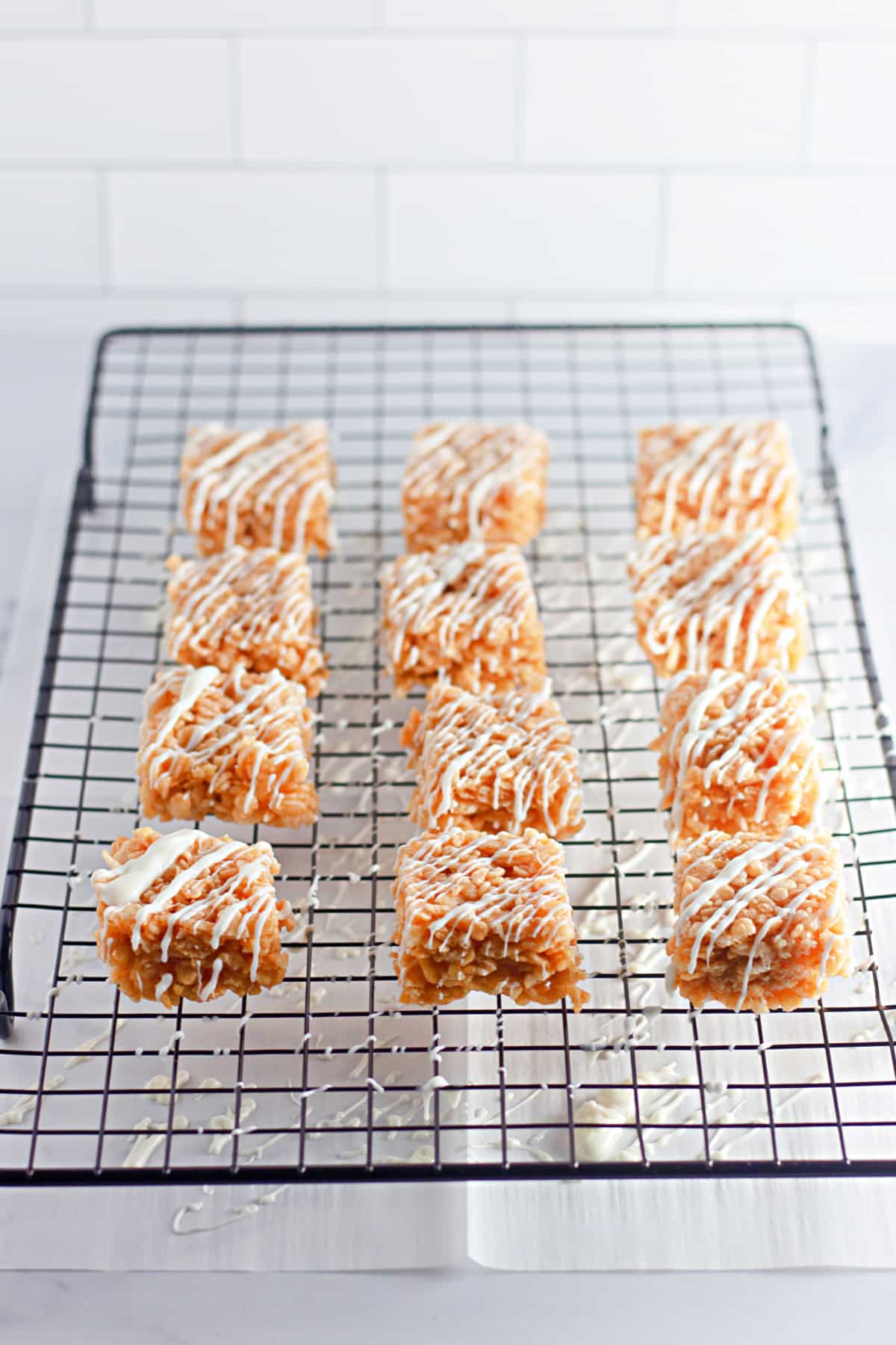 pumpkin rice krispies treats on a wire cooling rack.