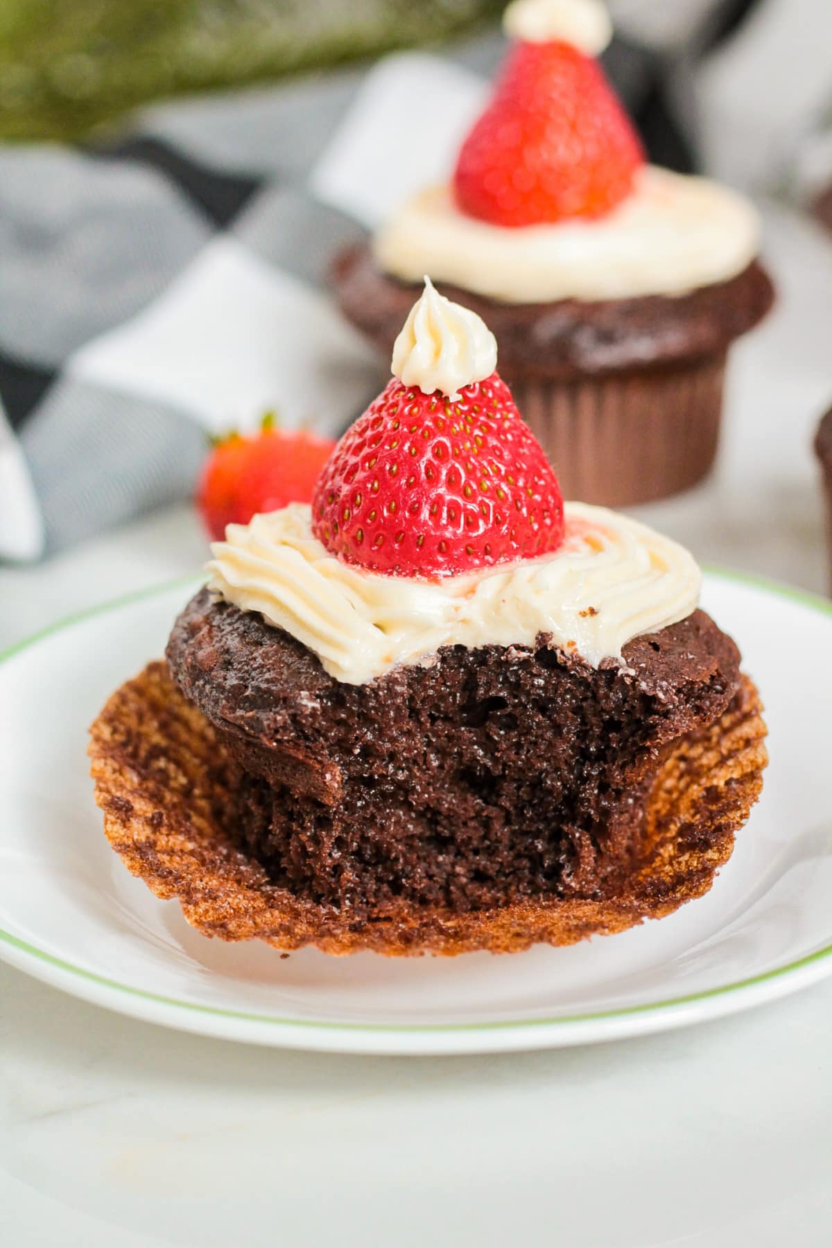 santa hat cupcake on a plate with a bite missing.