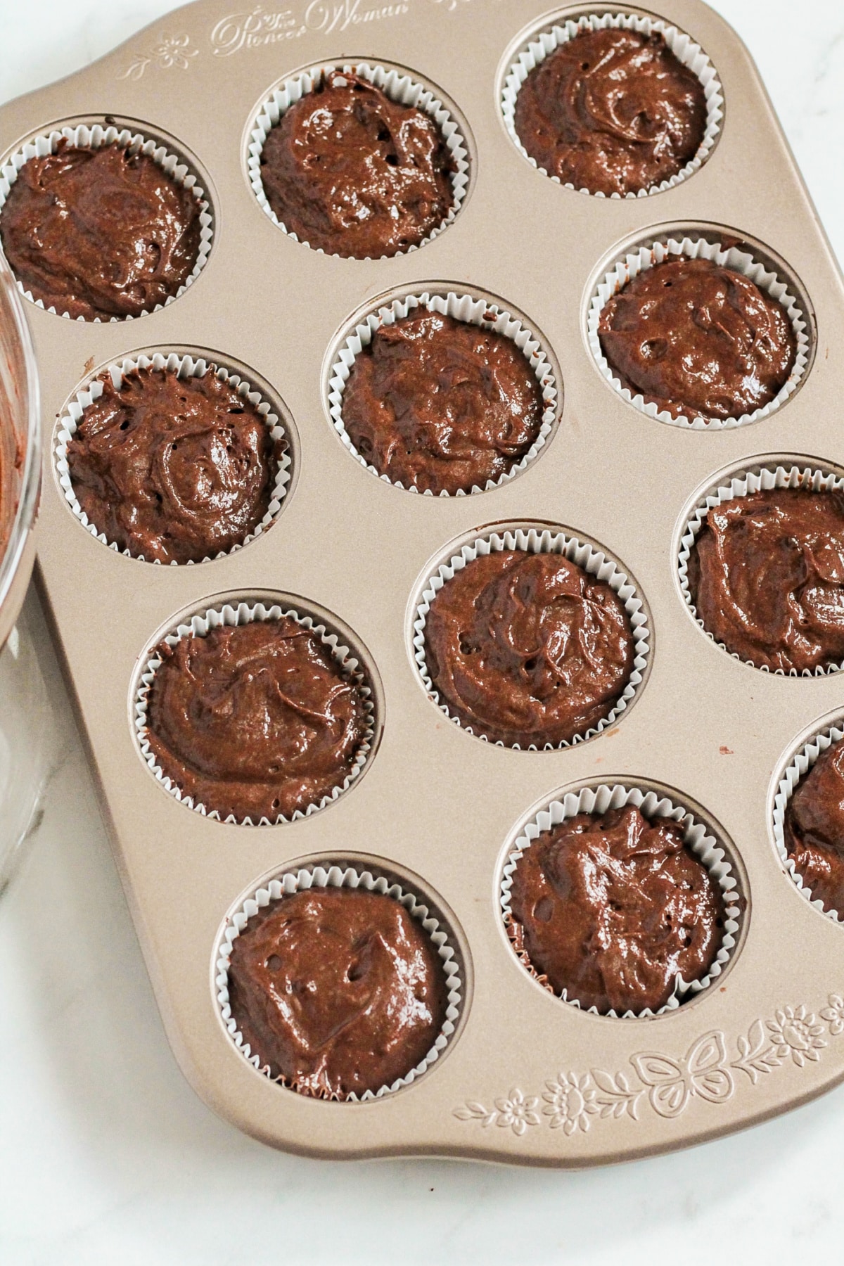 chocolate cupcake batter in a cupcake pan ready for the oven.