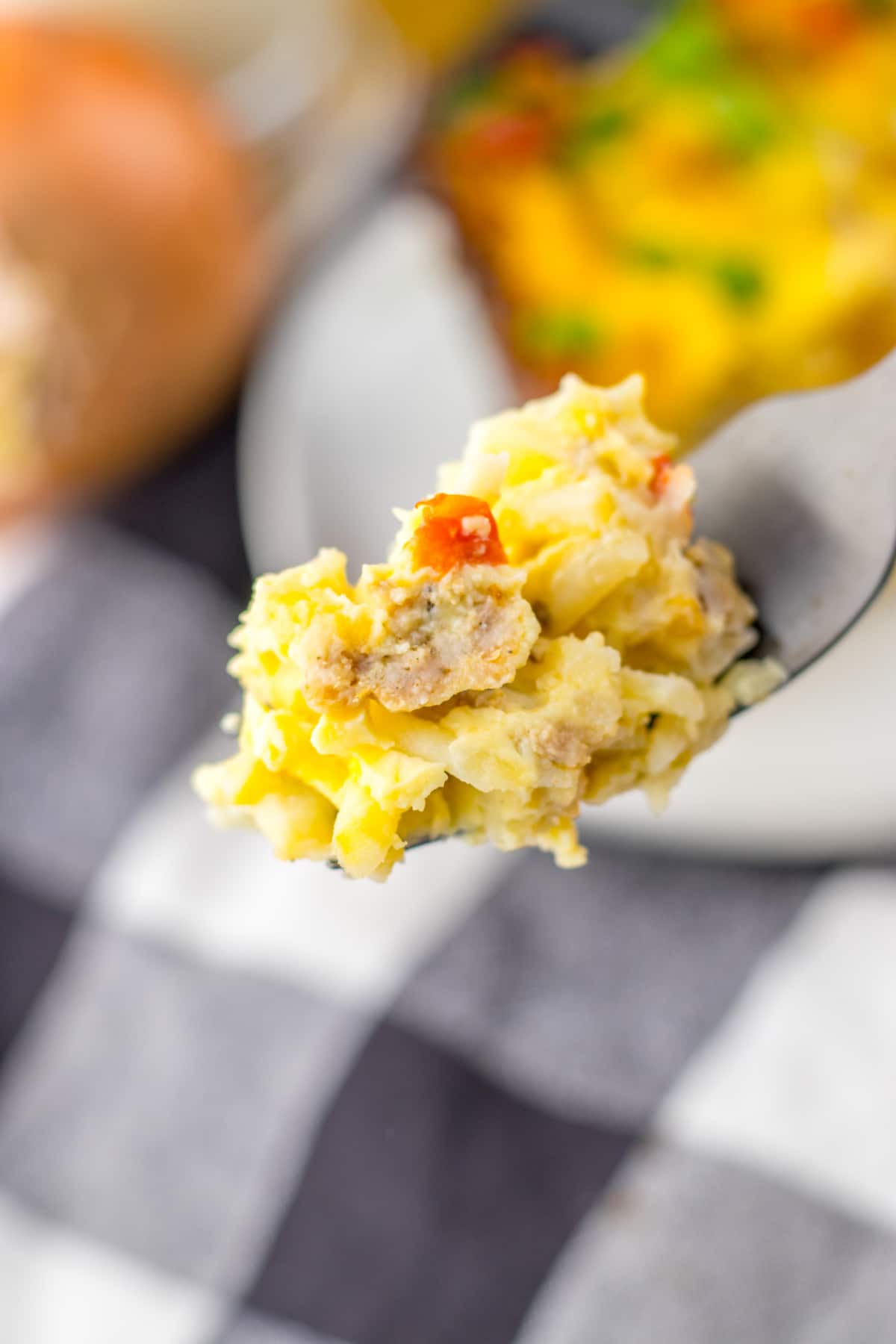 bite of breakfast casserole on a fork held in the air.