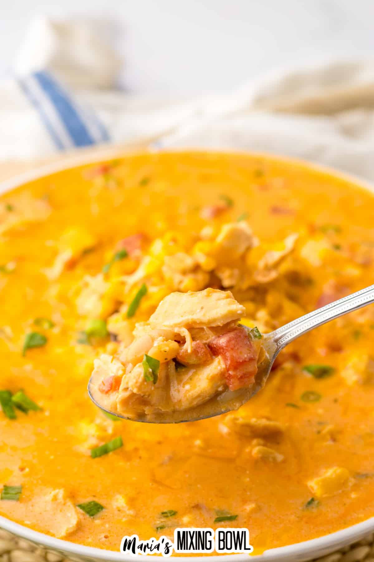 spoonful held of buffalo chicken chili held above a bowl full of it.