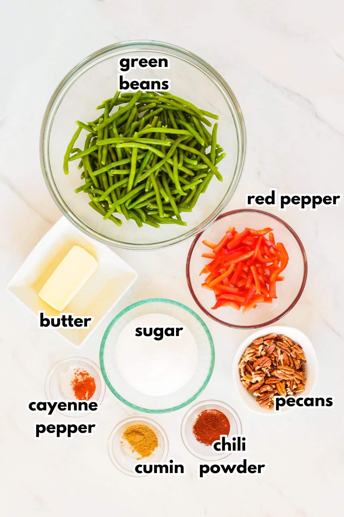 bowls of green beans, red pepper, butter, sugar, pecans, cayenne pepper, cumin, chili powder.