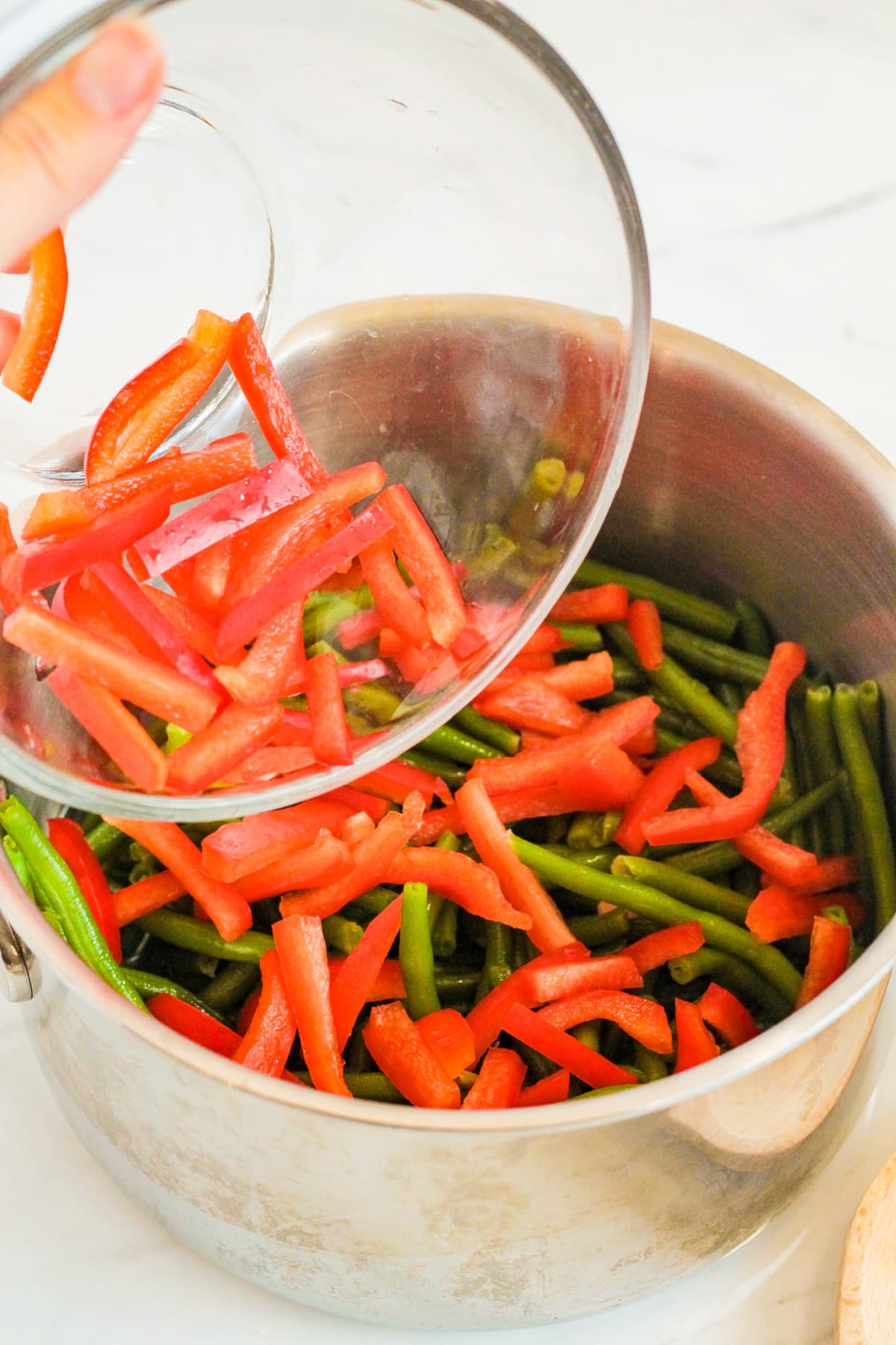 green beans and bell peppers being steamed in a large pot.