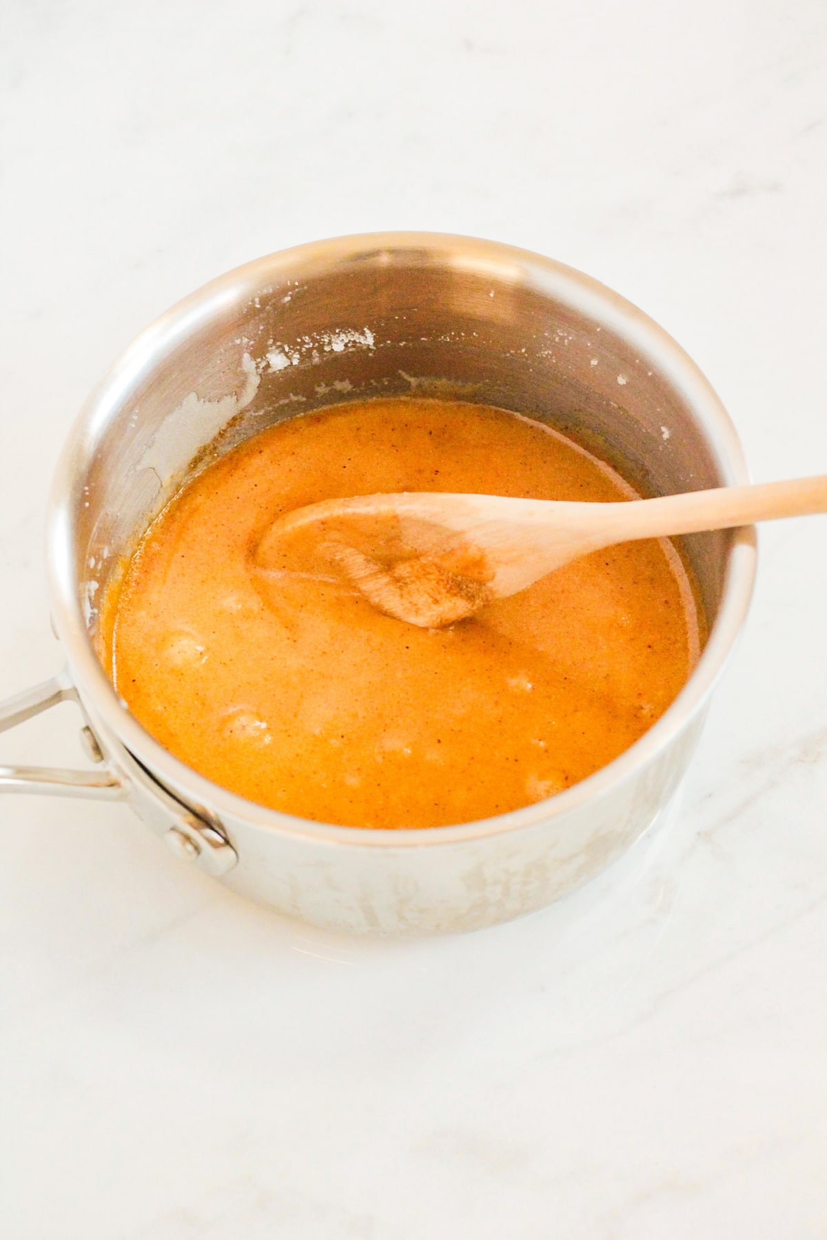 butter and seasonings being heated in a stainless steel saucepan.