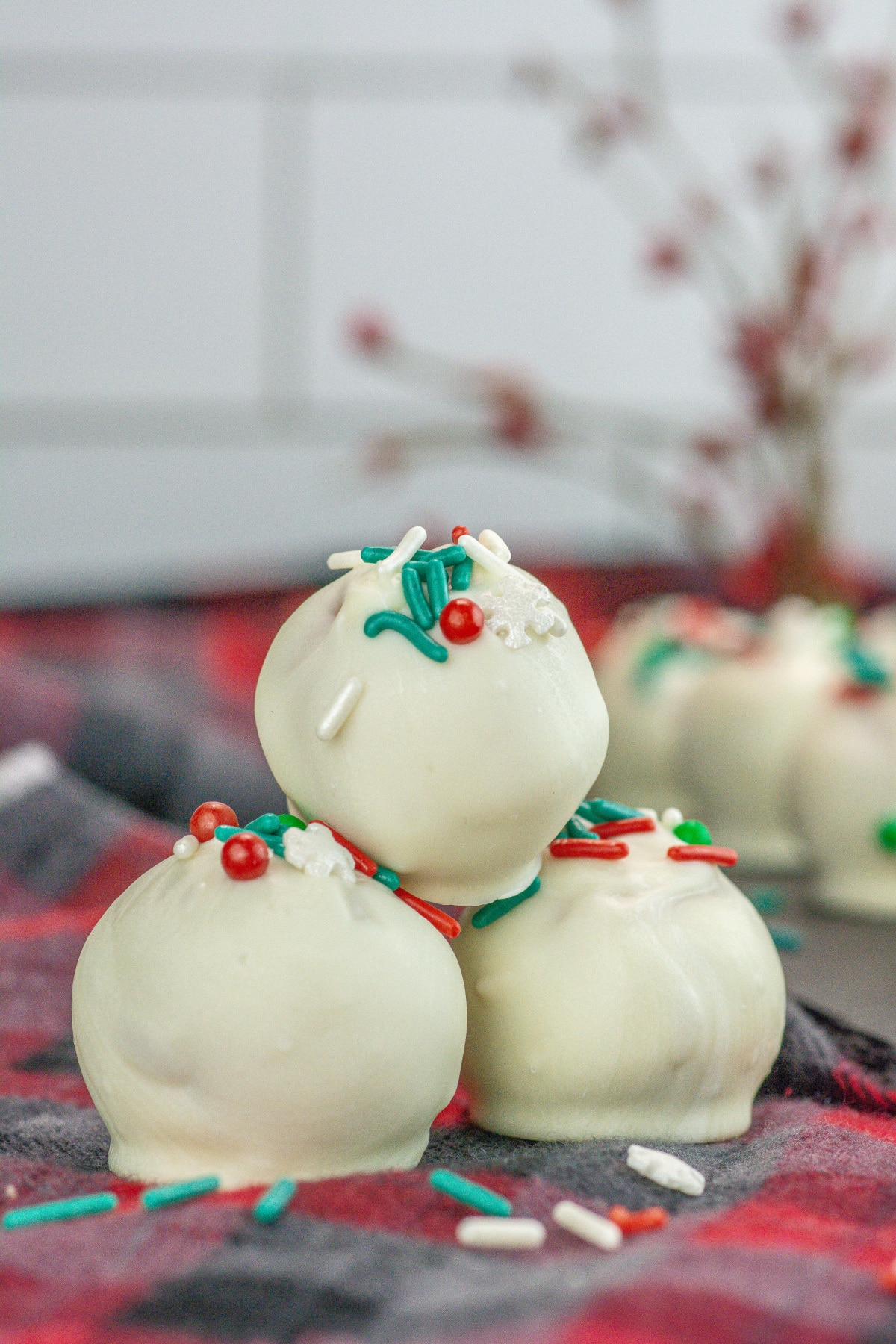sugar cookie truffles topped with sprinkles on a kitchen towel.