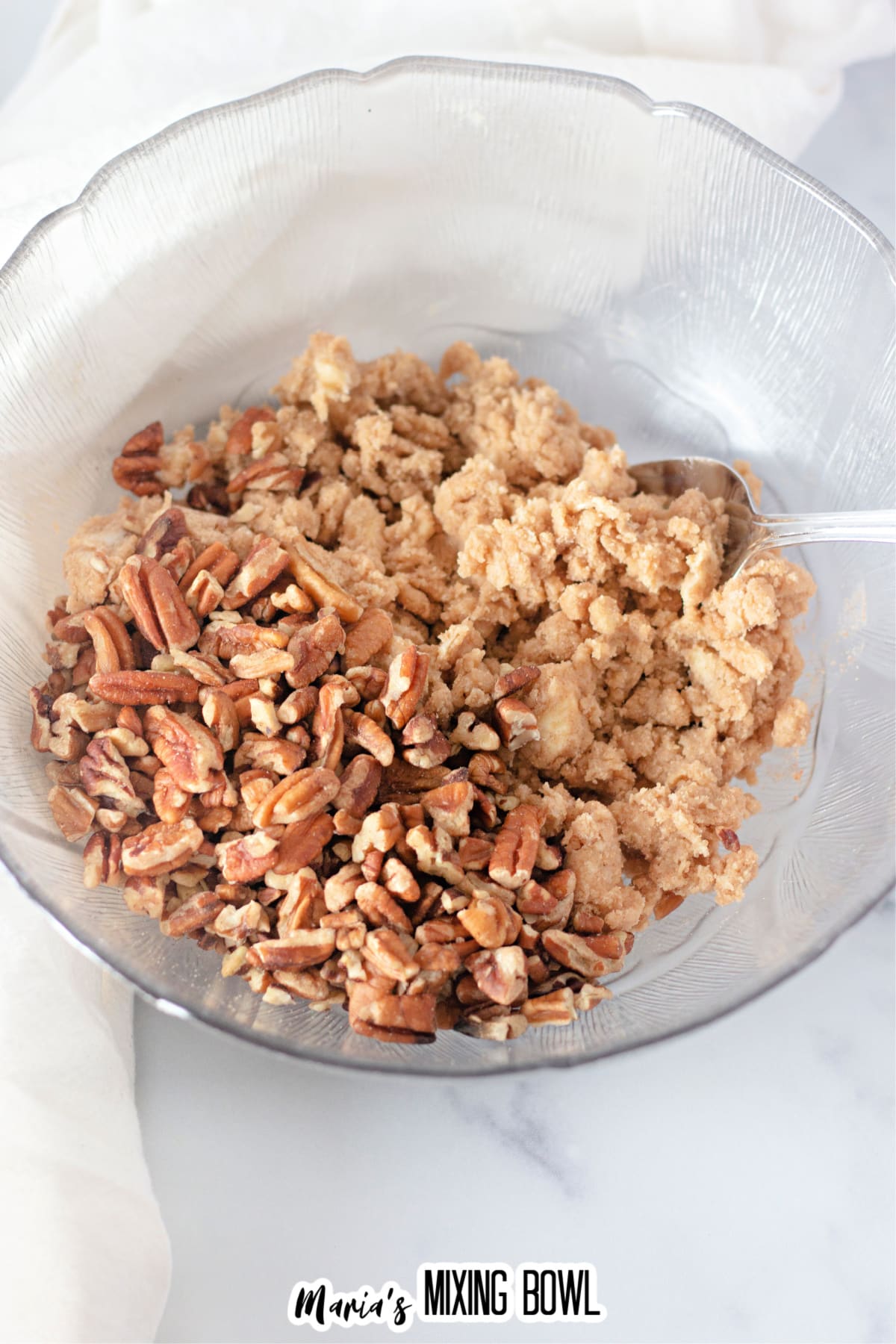 brown sugar, flour, and pecans being mixed together in a bowl.