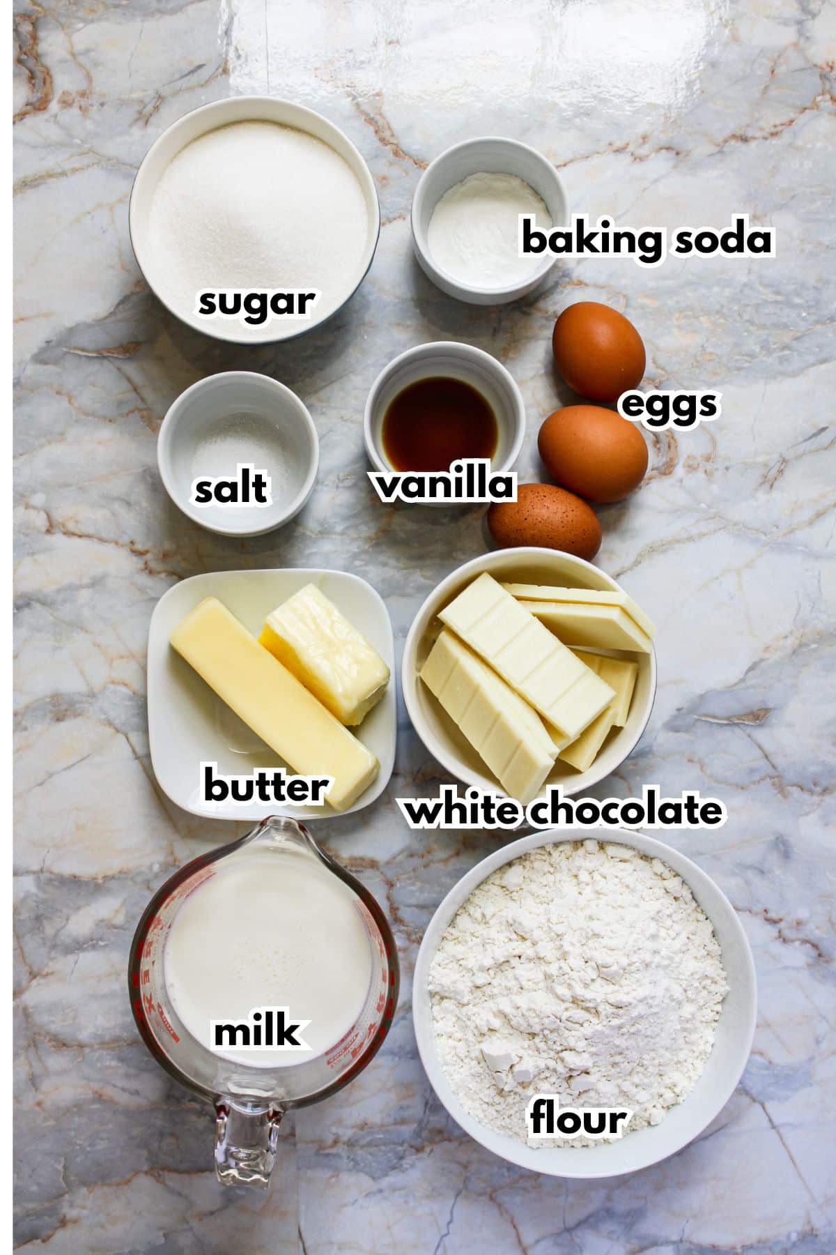 bowls of sugar, baking soda, salt, vanilla, eggs, butter, white chocolate, milk and flour.