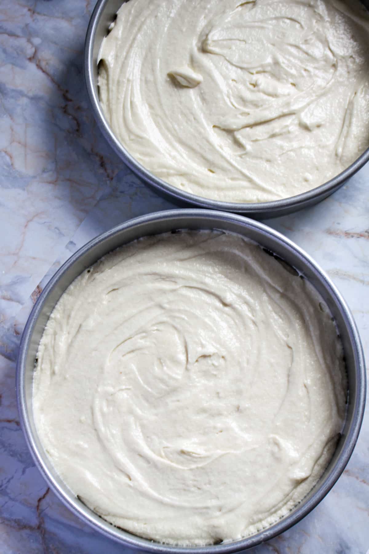 cake batter in two cake rounds ready for the oven.