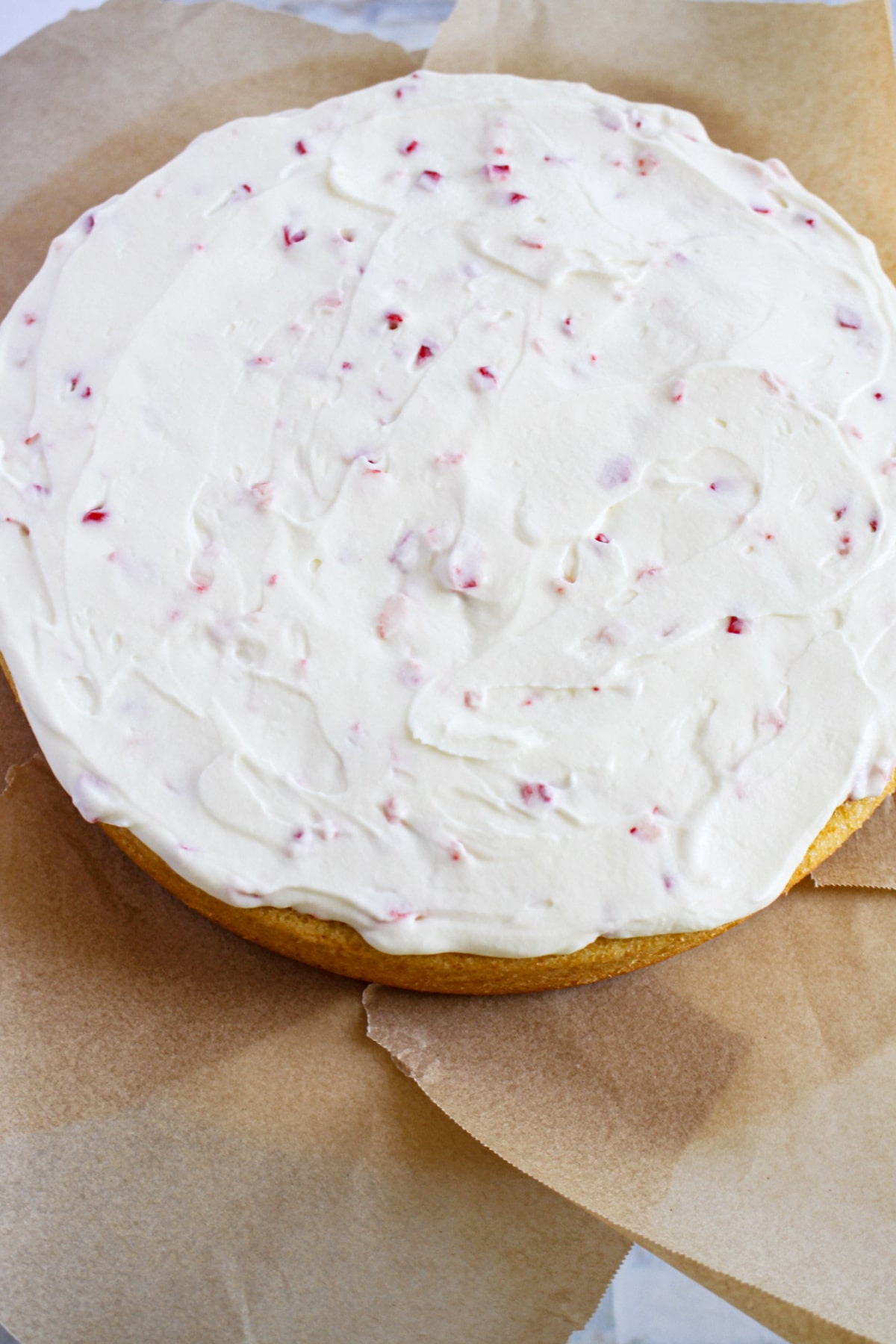 peppermint mousse being spread on top of a cake.
