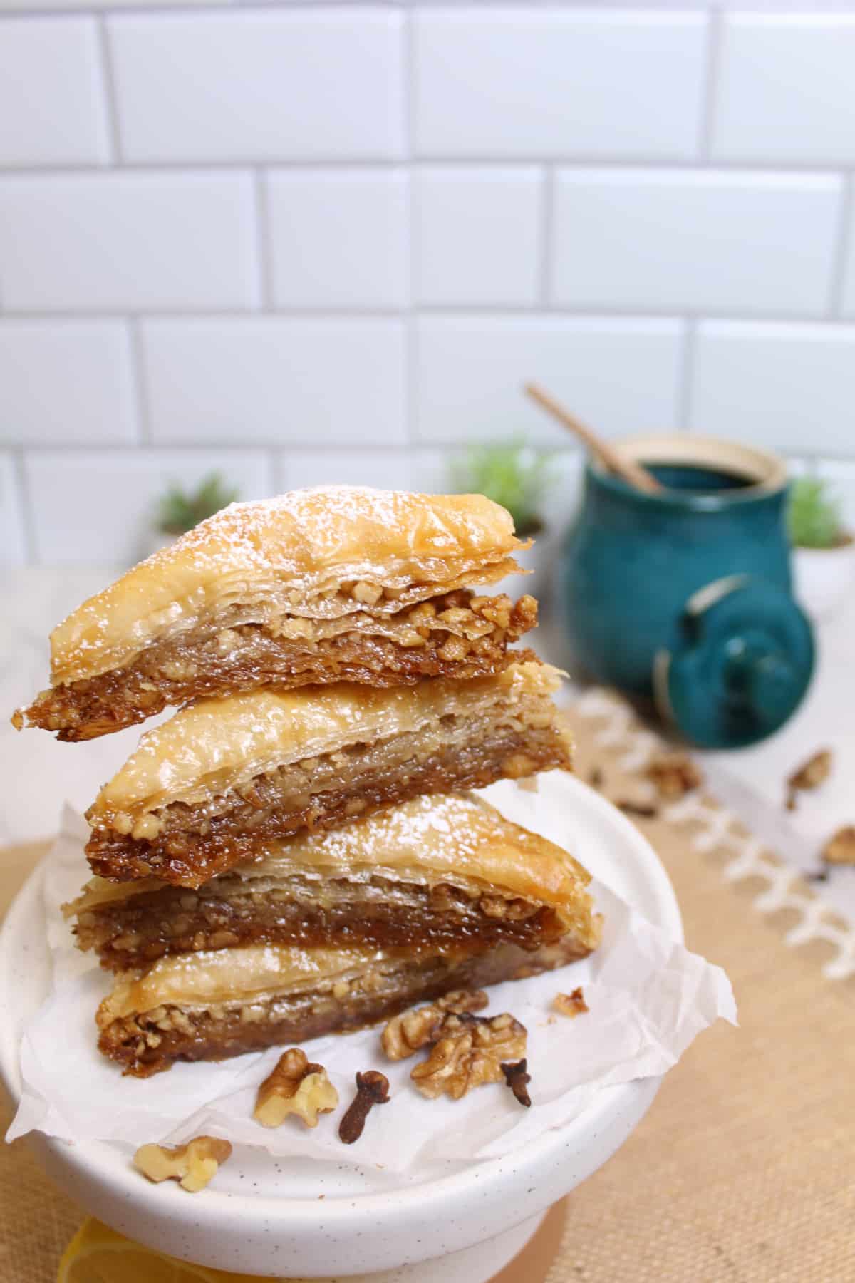 four pieces of baklava stacked on top of each other one a cake stand.
