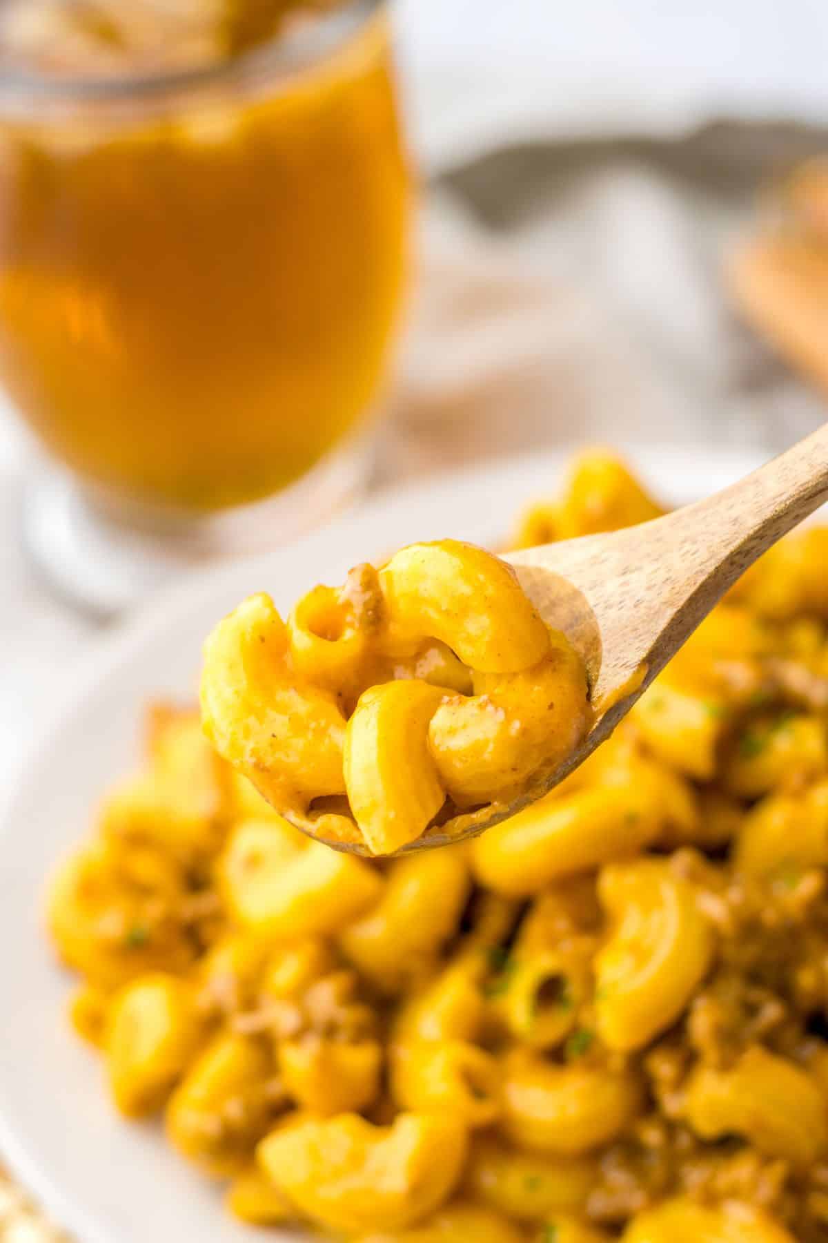 wooden spoon full of one pot cheeseburger pasta held in the air.