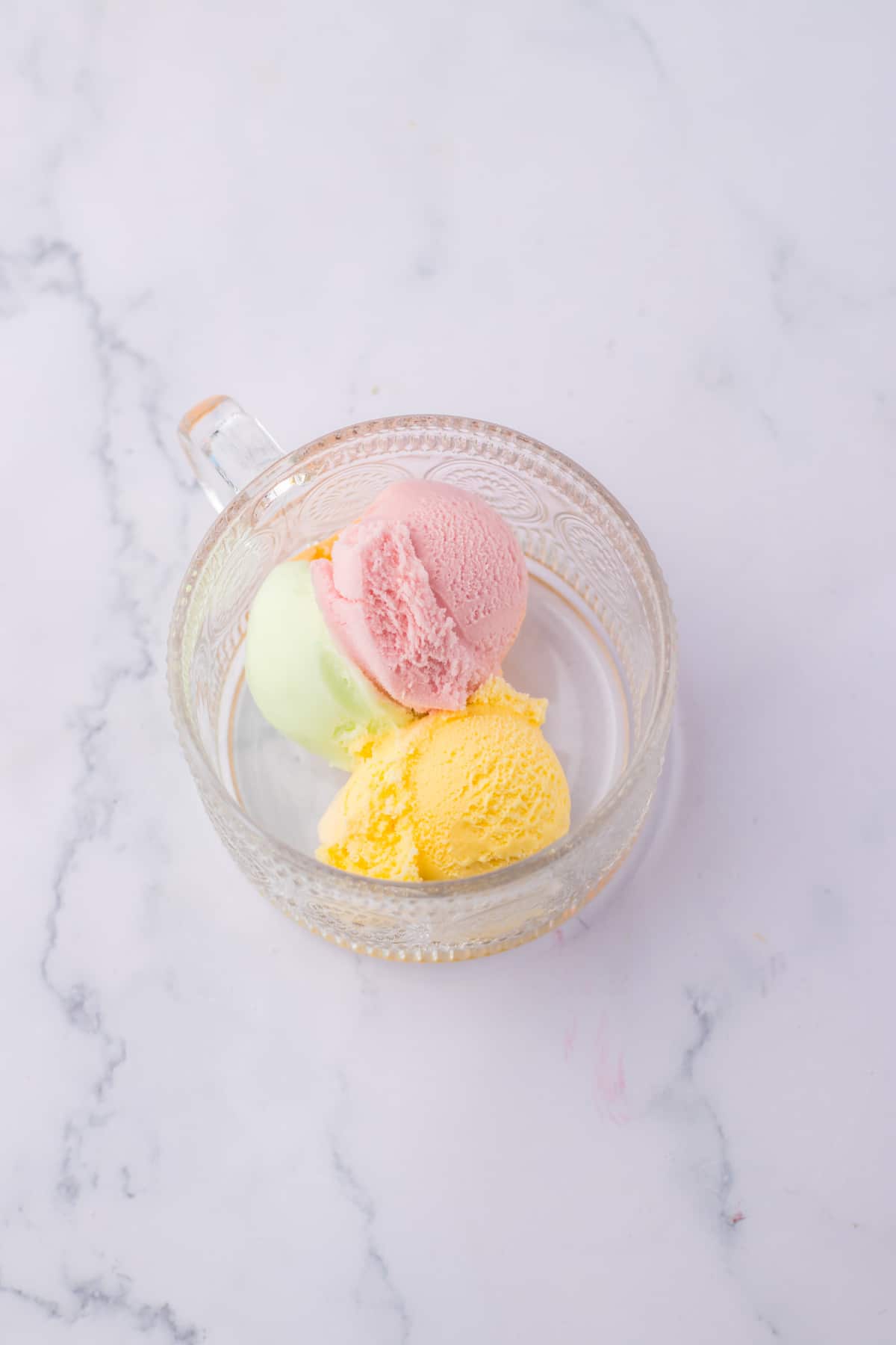 rainbow sherbet scooped into a glass mug.
