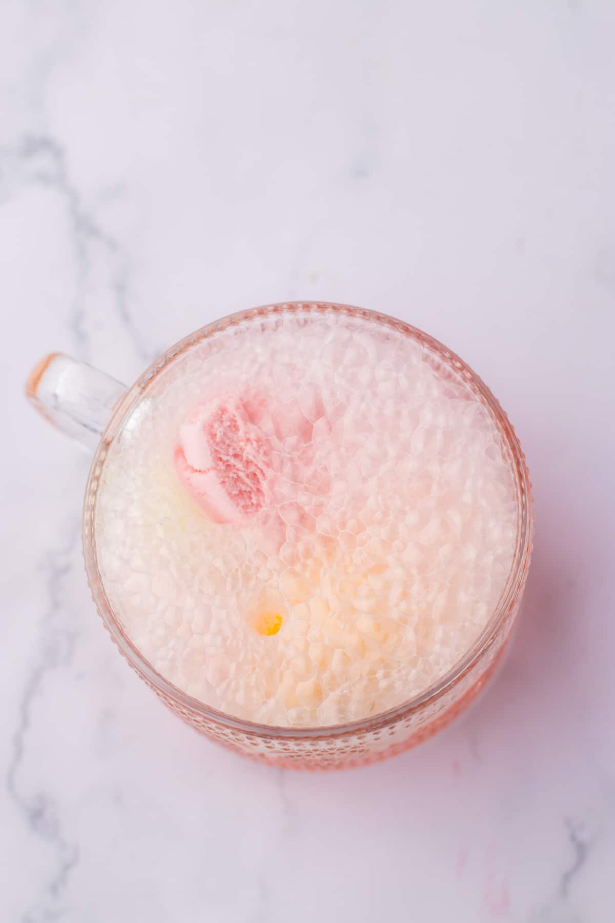 cherry 7up being poured onto of rainbow sherbet in a glass mug.