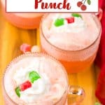 mug of cherry punch topped with whipped cream and gumdrops.