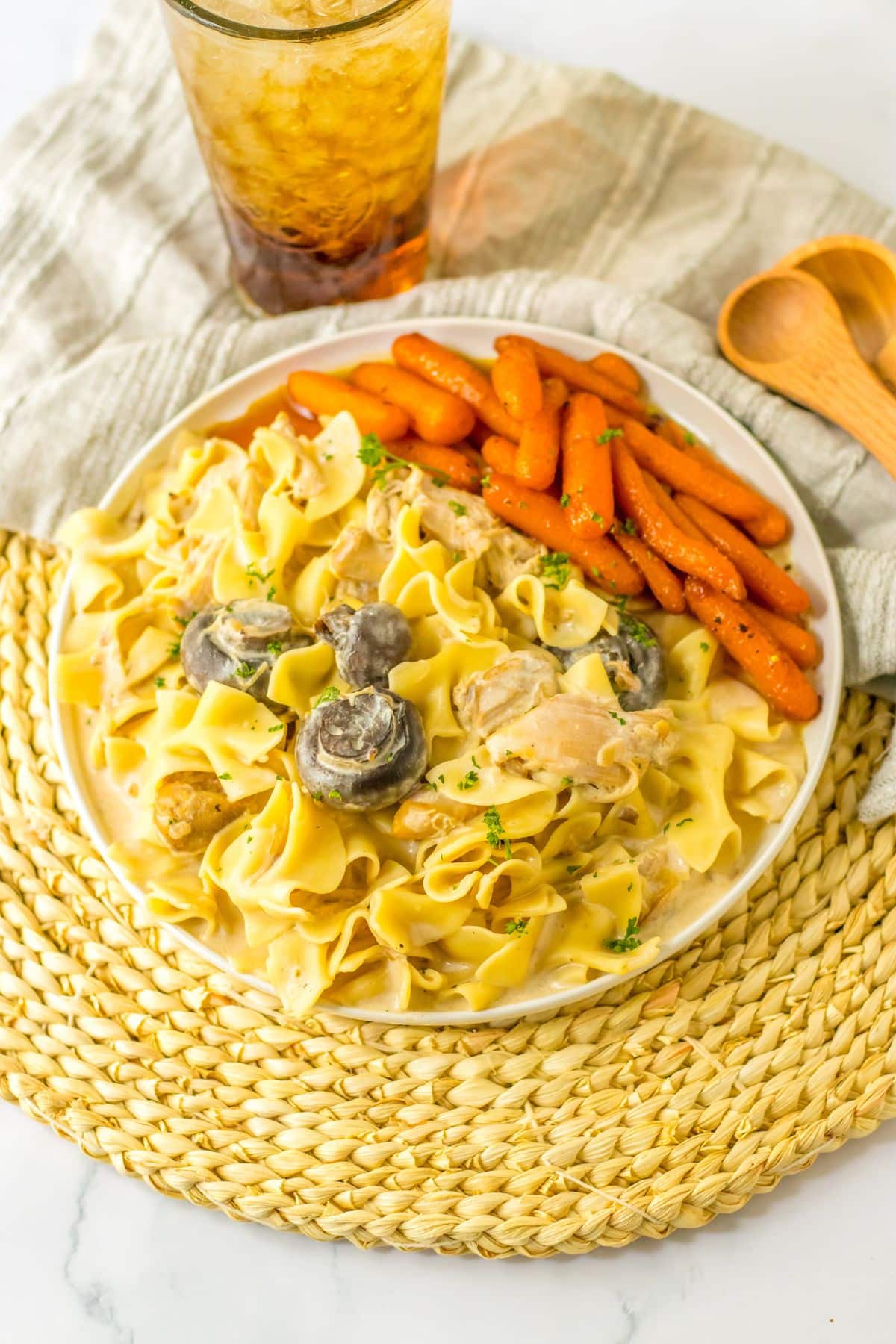 plate filled with slow cooker chicken mushroom stroganoff and a side of carrots.