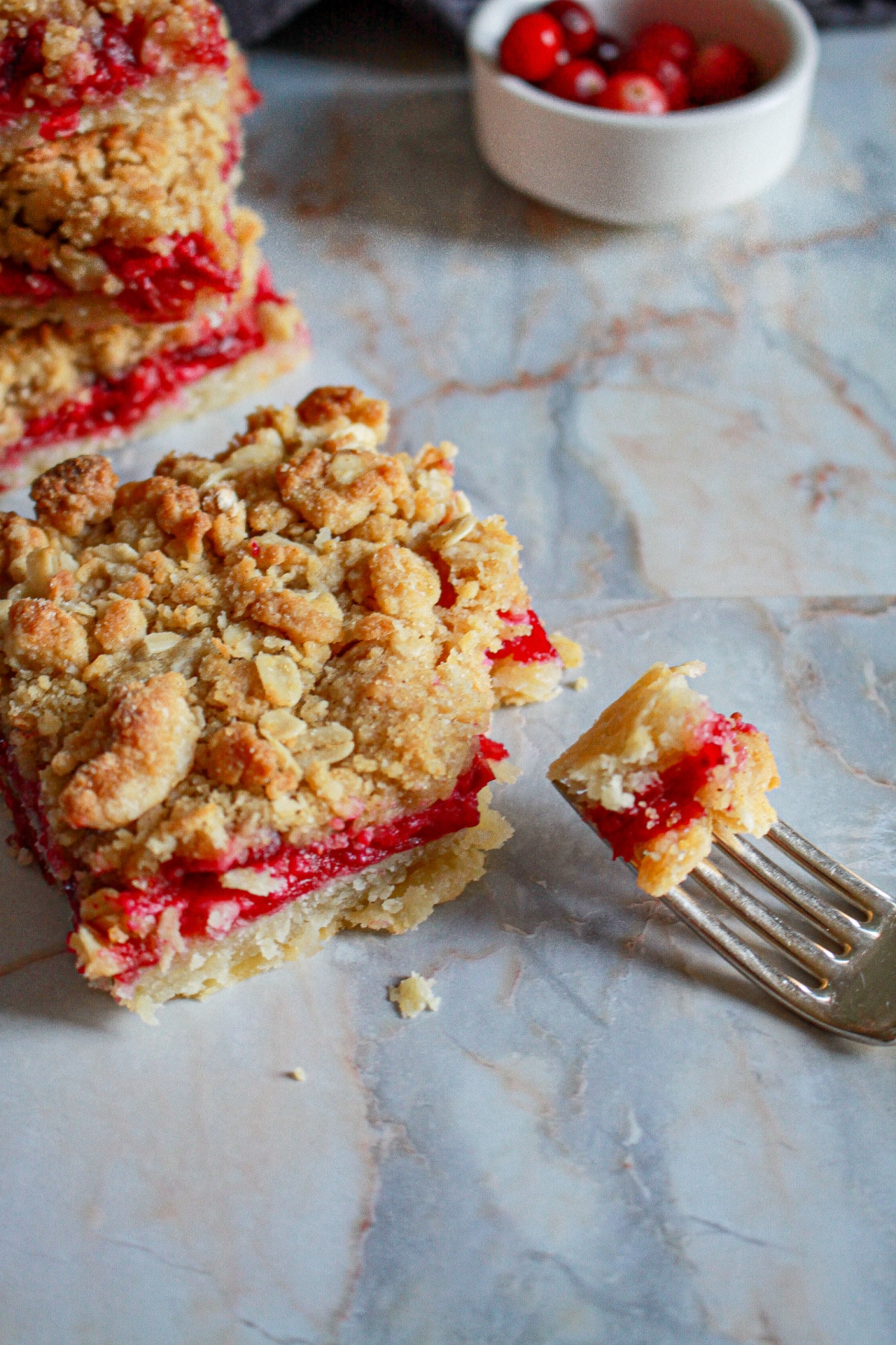 slice of cranberry crumble bars with a bite missing.