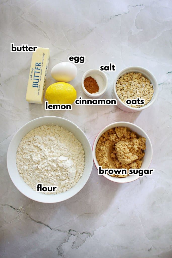 bowls of flour, butter, egg, lemon, cinnamon, salt, oats, flour and brown sugar.