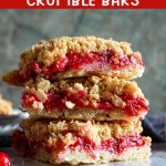 three cranberry crumble bars stacked on top of one another.