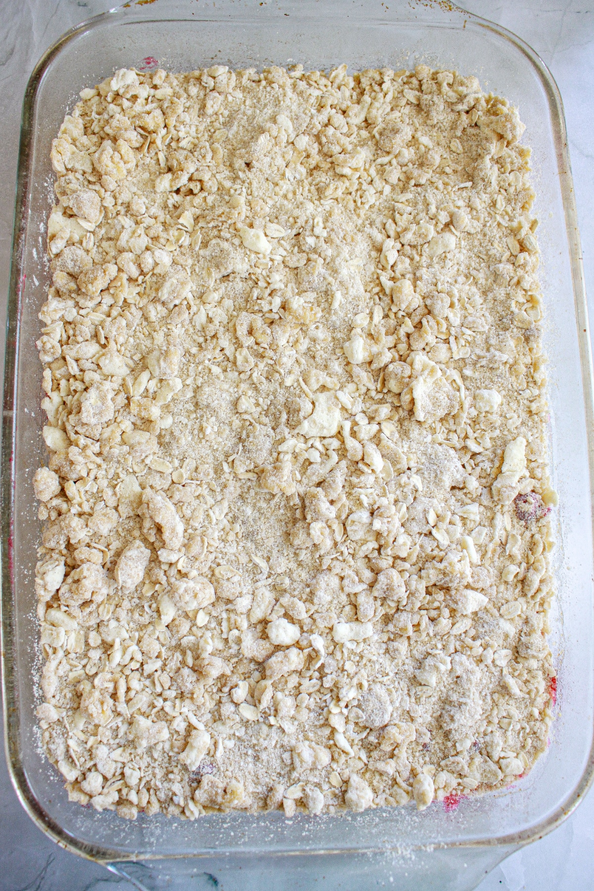 cranberry crumble bars unbaked in a glass baking dish.