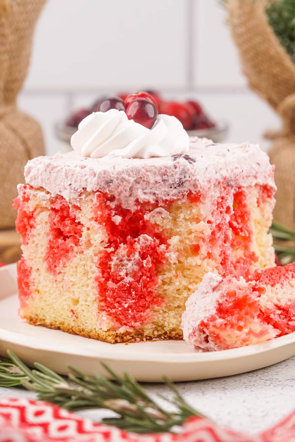 slice of cranberry poke cake on a small plate.
