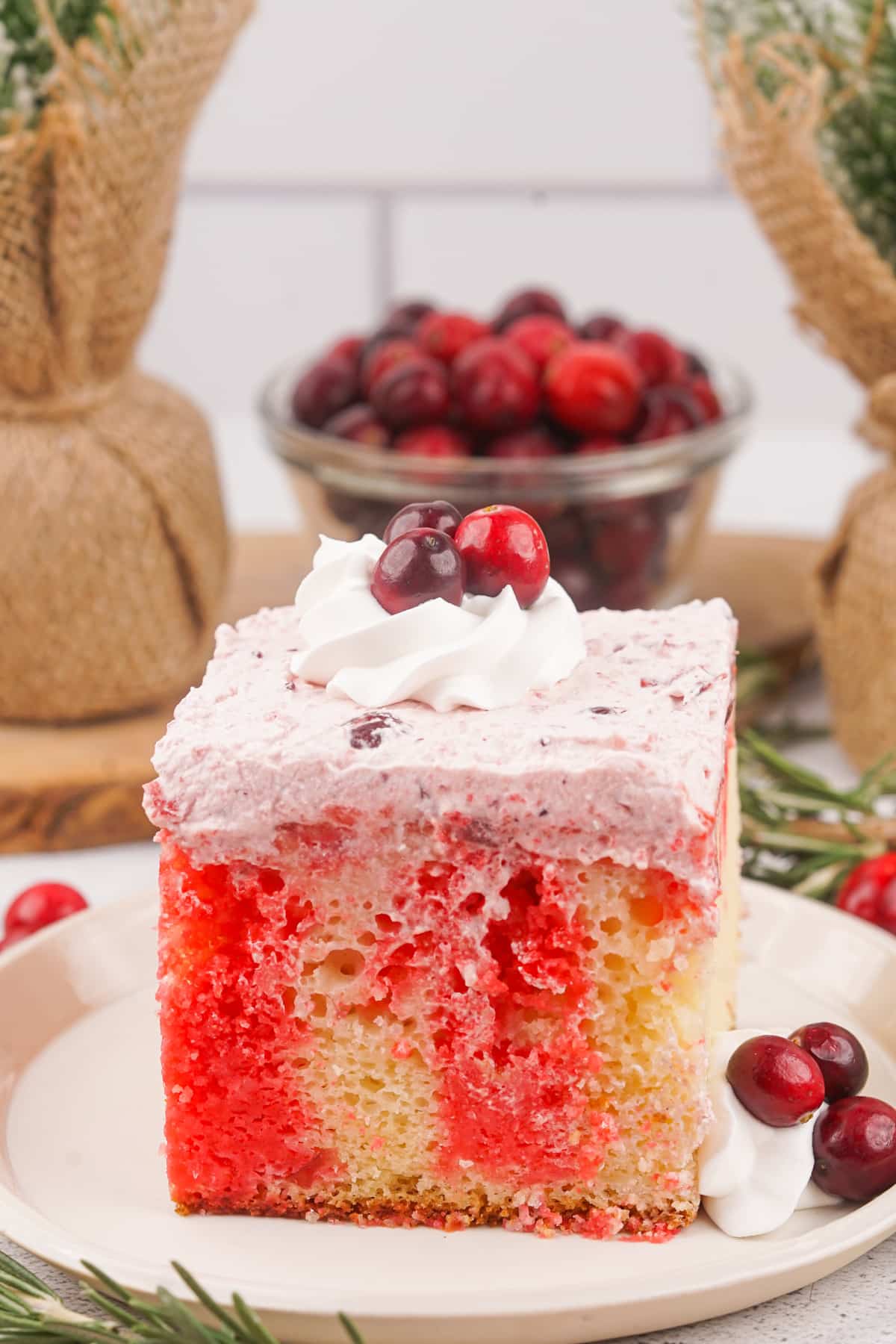 slice of cranberry poke cake on a small plate.