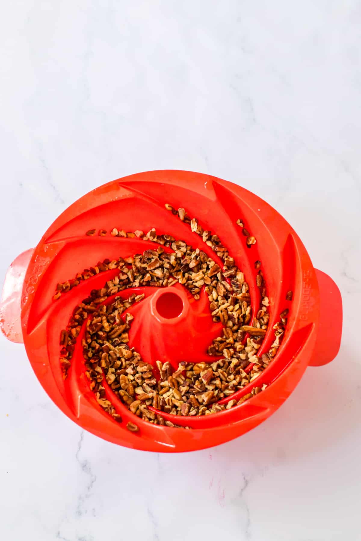 pecans in the bottom of a silicone bundt pan.