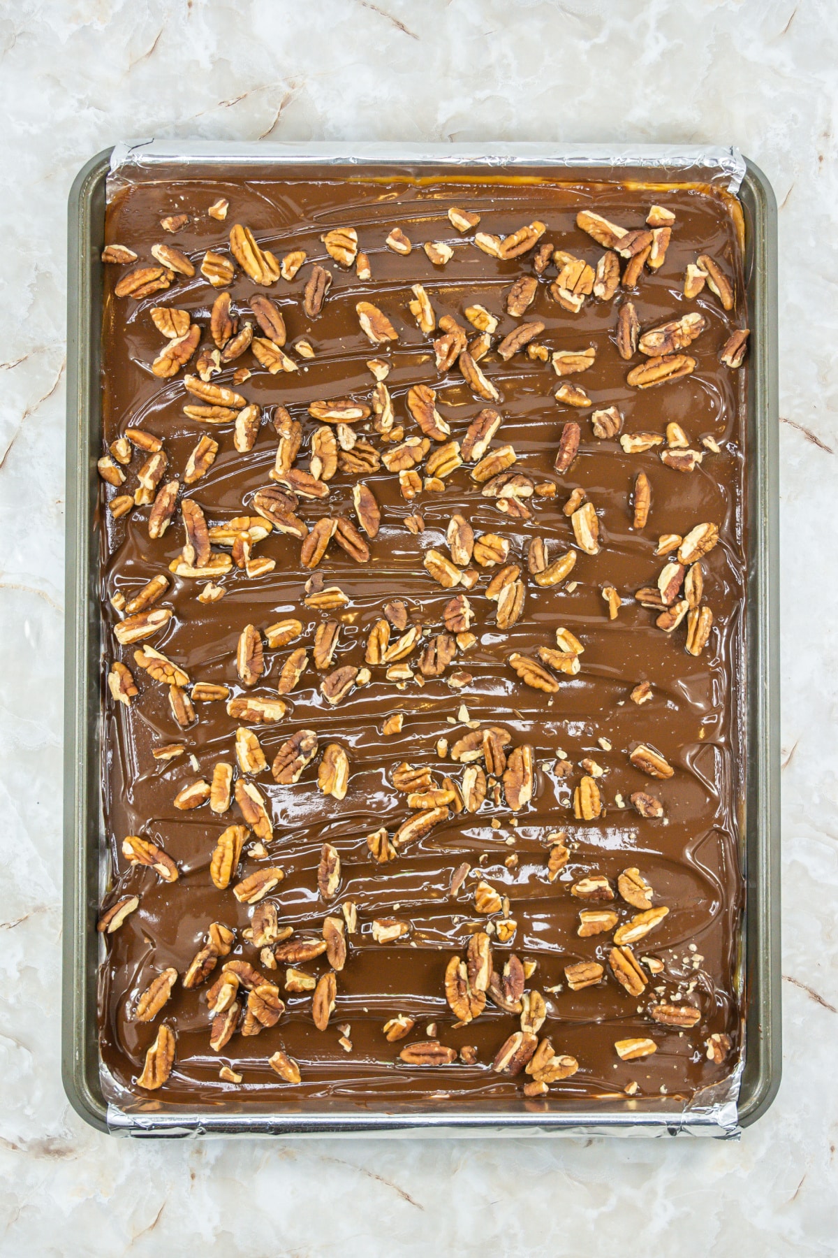 finish candy in a baking dish topped with chocolate and pecans.