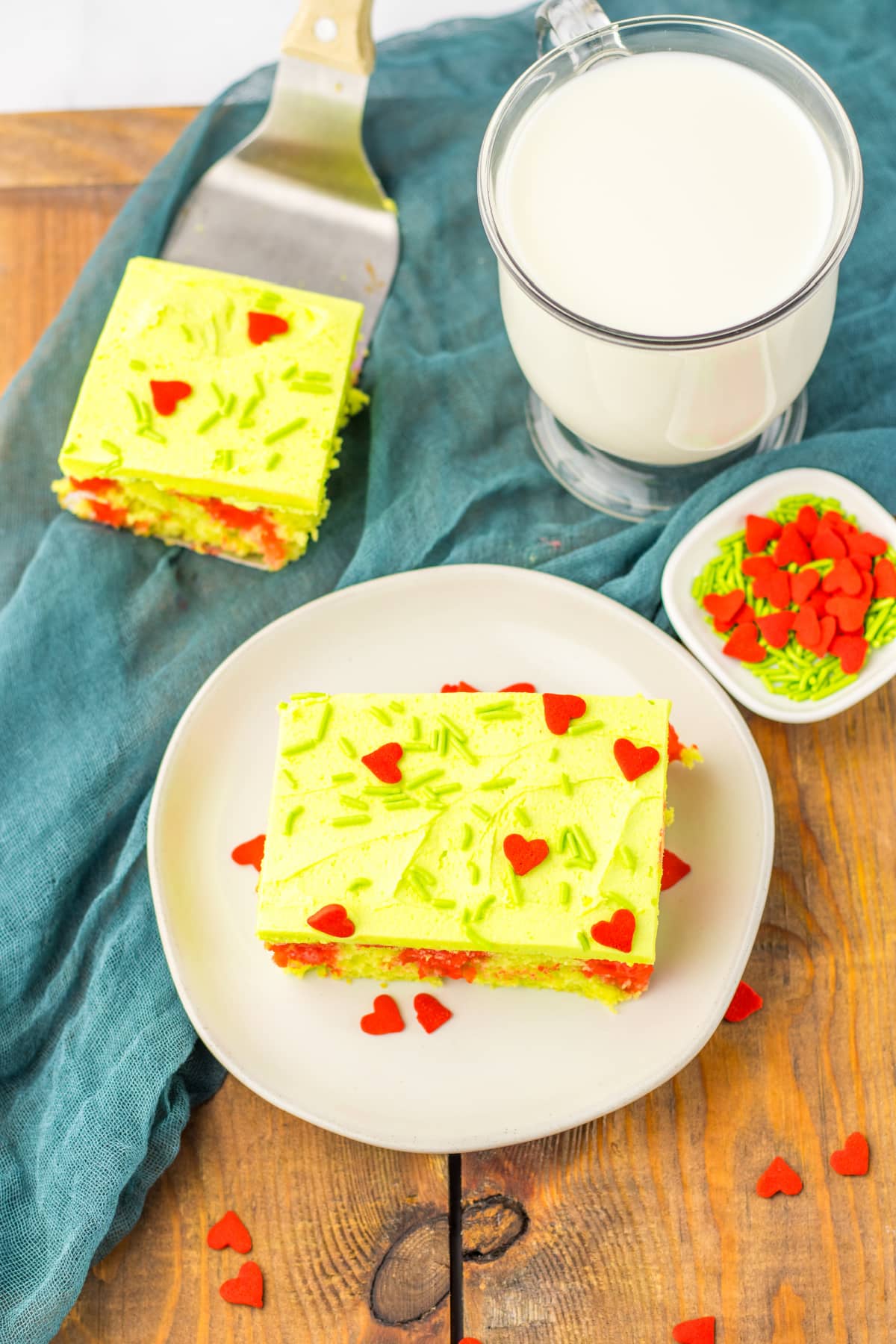 slice of grinch poke cake on a white plate.