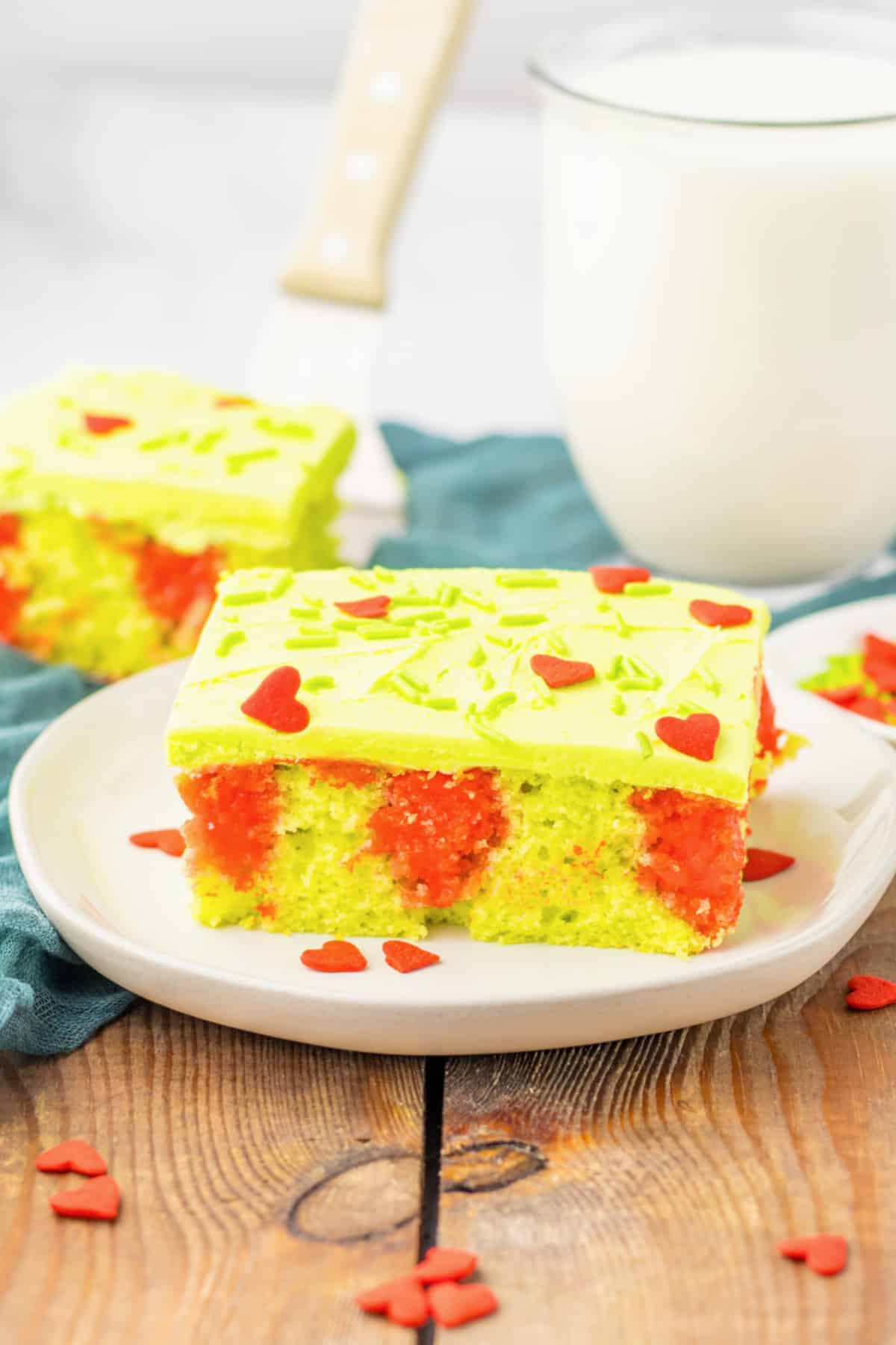 slice of grinch poke cake on a white plate.