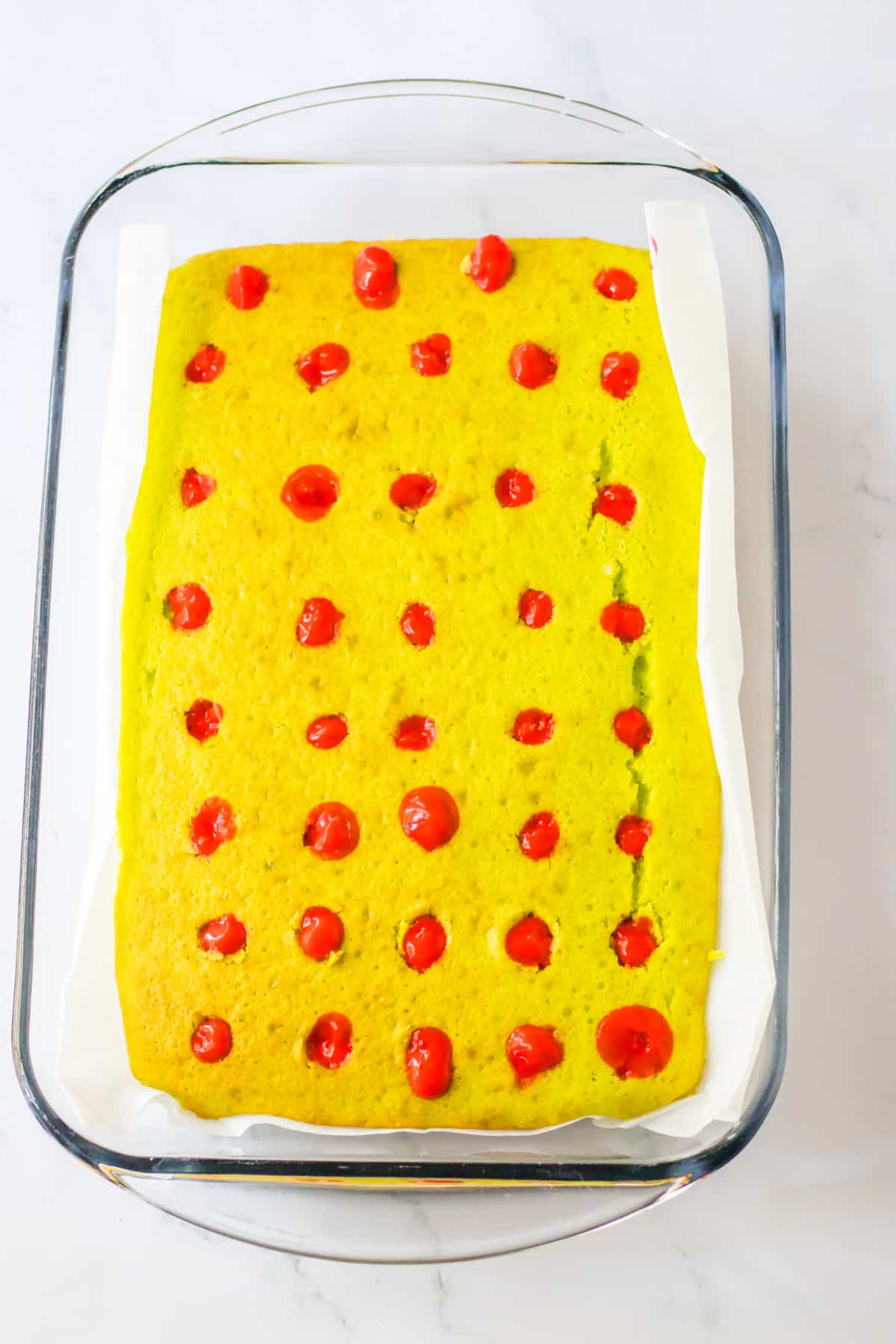 pudding being poured into holes in a baked cake.