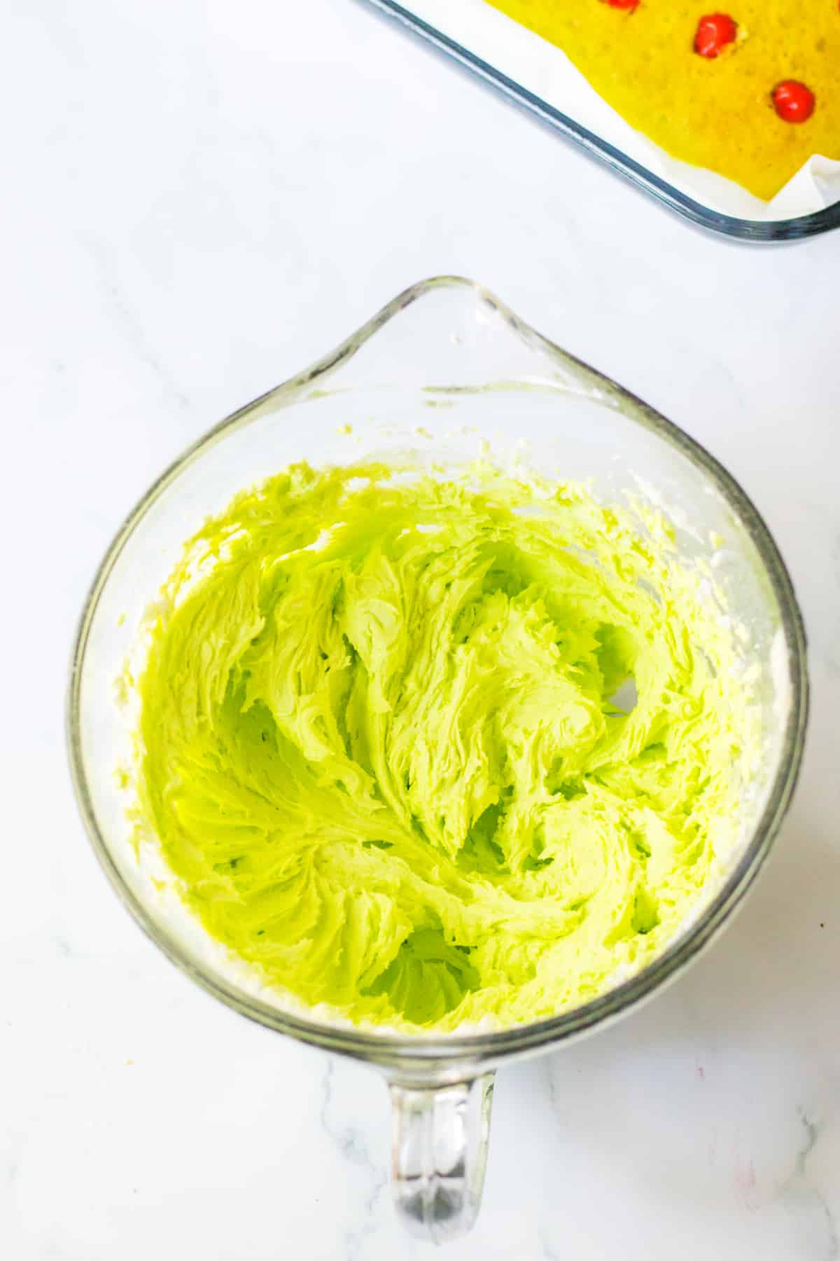 green frosting in a glass mixing bowl.