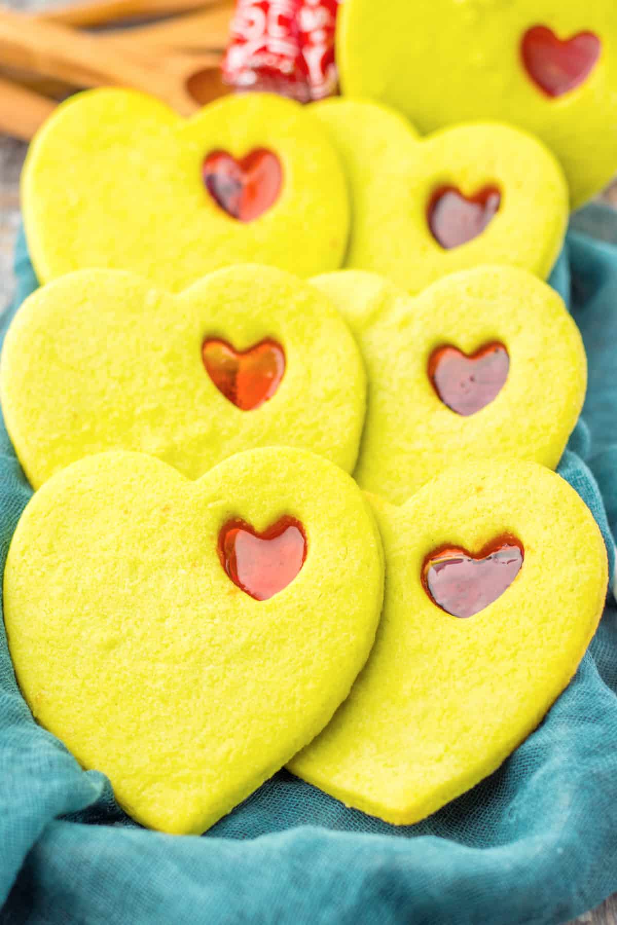 stained glass cookies on a baking tray covered with a kitchen towels.