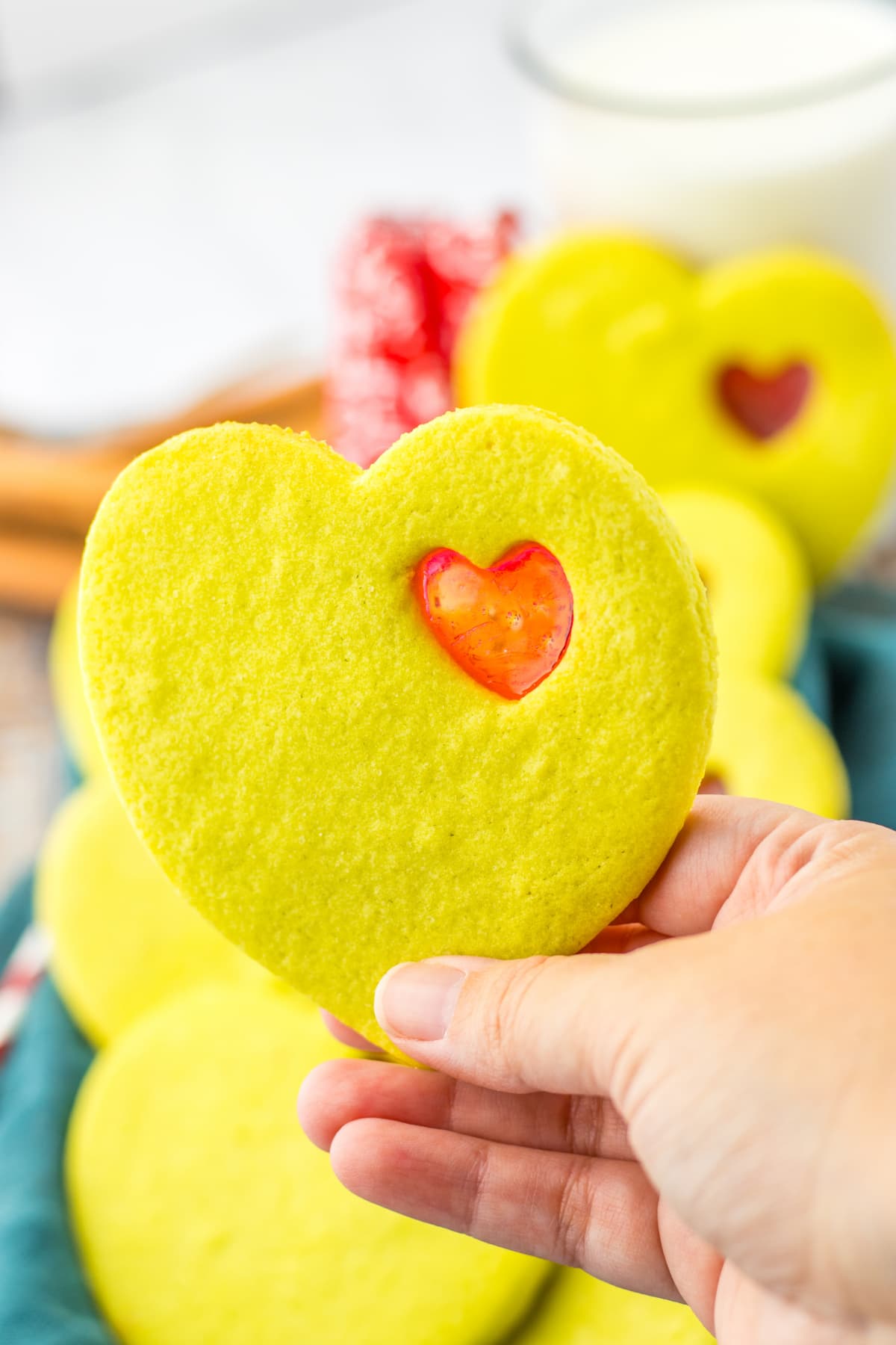 grinch stained glass cookie held in a woman's hand.