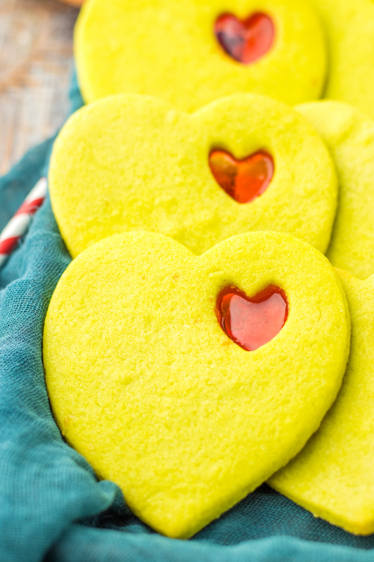 stained glass cookies on a baking tray covered with a kitchen towels.
